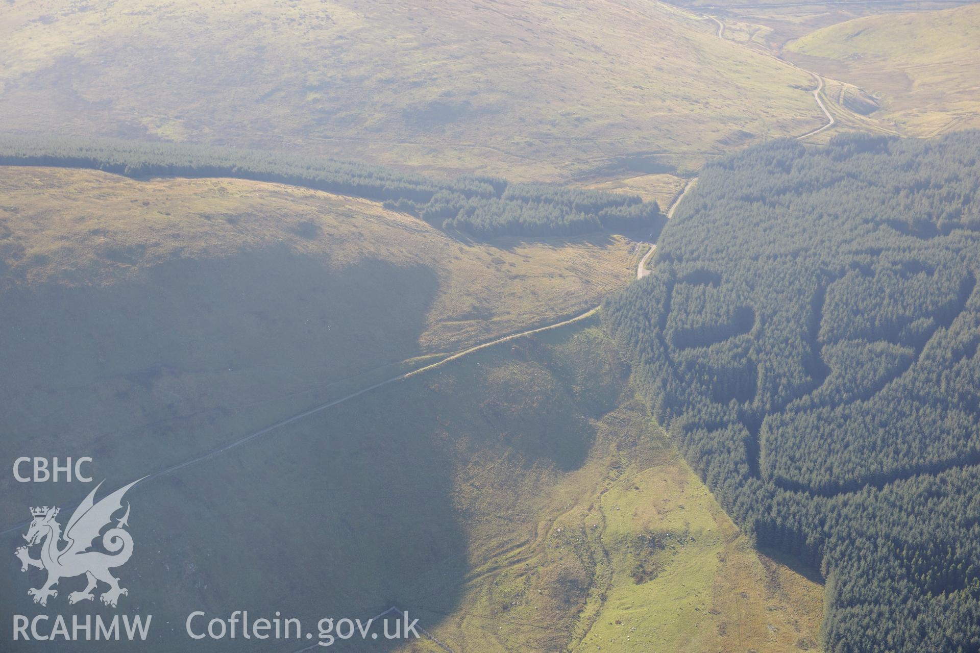 Bedd-y-Brenin cairn and cist, hidden in trees a mile and a half south east of Fairbourne. Oblique aerial photograph taken during the Royal Commission's programme of archaeological aerial reconnaissance by Toby Driver on 2nd October 2015.