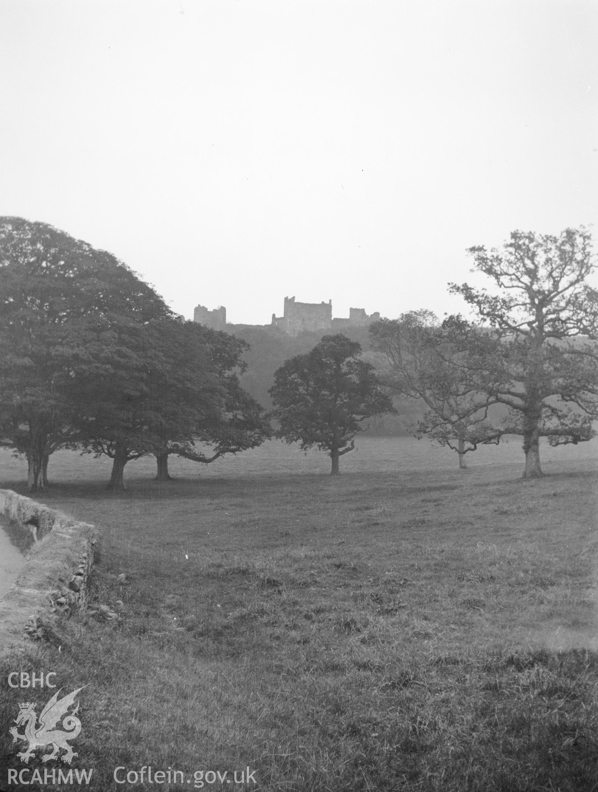 Digital copy of a nitrate negative showing distant view of Llanstephan Castle, from park land. From the National Building Record Postcard Collection.