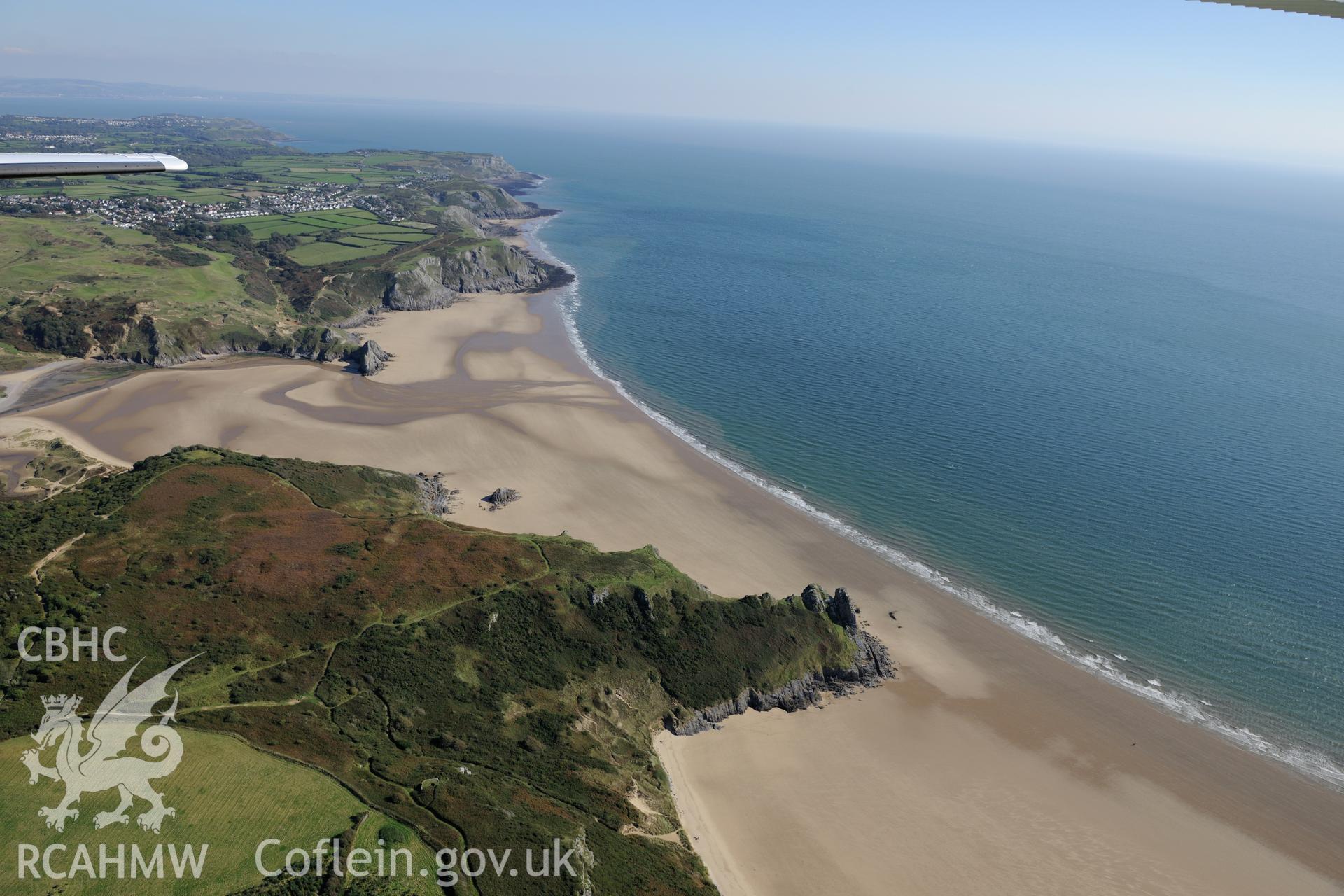 Threecliffs Bay and the pillowmound on the Great Tor Headland, on the southern coast of the Gower Peninsula. Oblique aerial photograph taken during the Royal Commission's programme of archaeological aerial reconnaissance by Toby Driver on 30th September 2015.