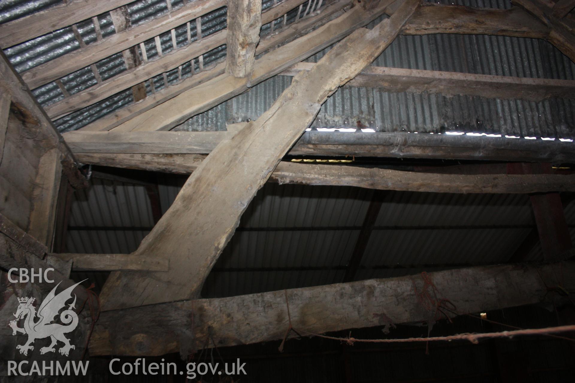 Interior view of shed or barn showing timber frame and roof beams, and a corrugated iron roof. Photographic survey of Glanhafon-Fawr Farmstead conducted by Geoff Ward on 4th November 2010.