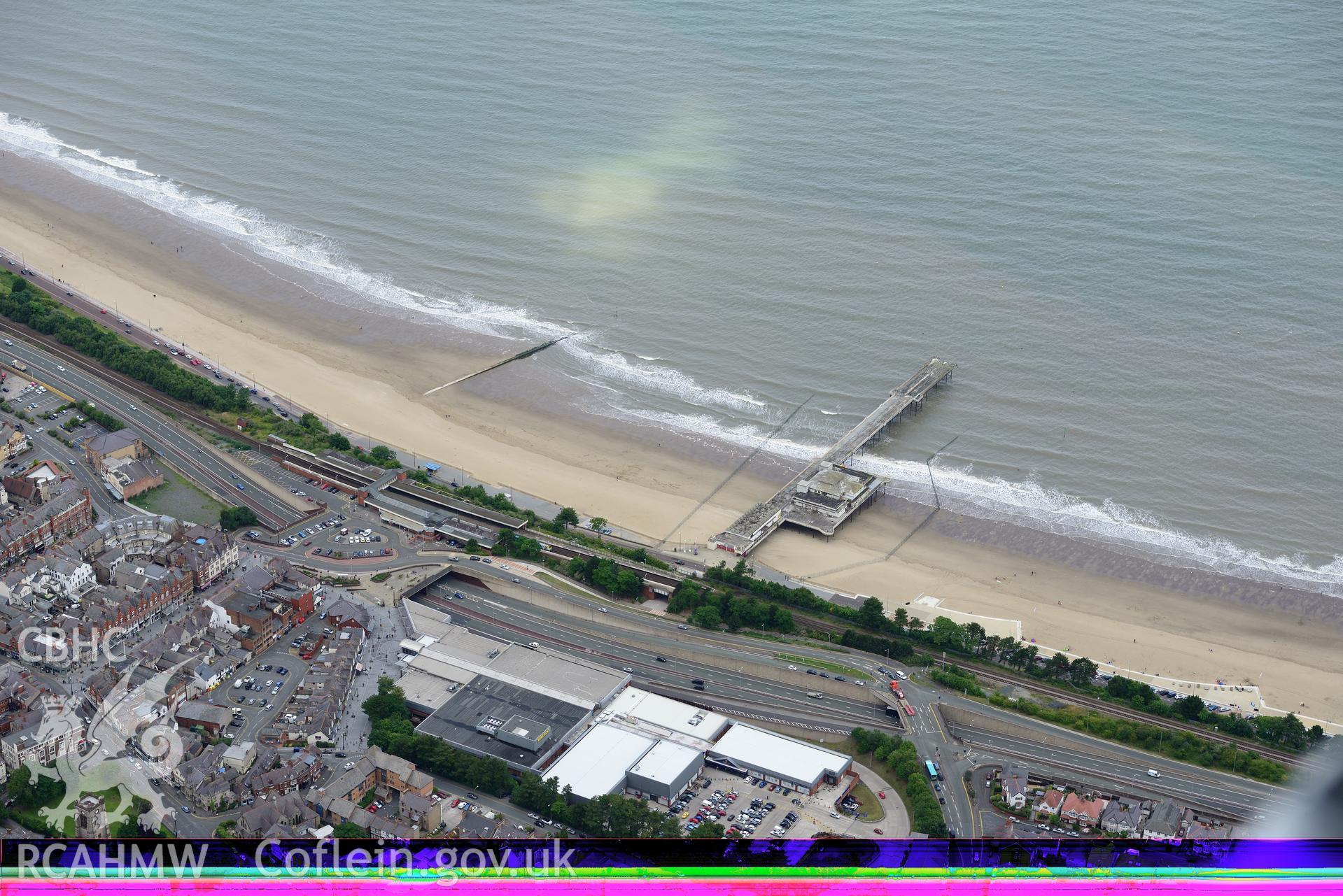 Victoria Pier and Pavilion, Railway Station and St. Paul's Church, Colwyn Bay. Oblique aerial photograph taken during the Royal Commission's programme of archaeological aerial reconnaissance by Toby Driver on 30th July 2015.