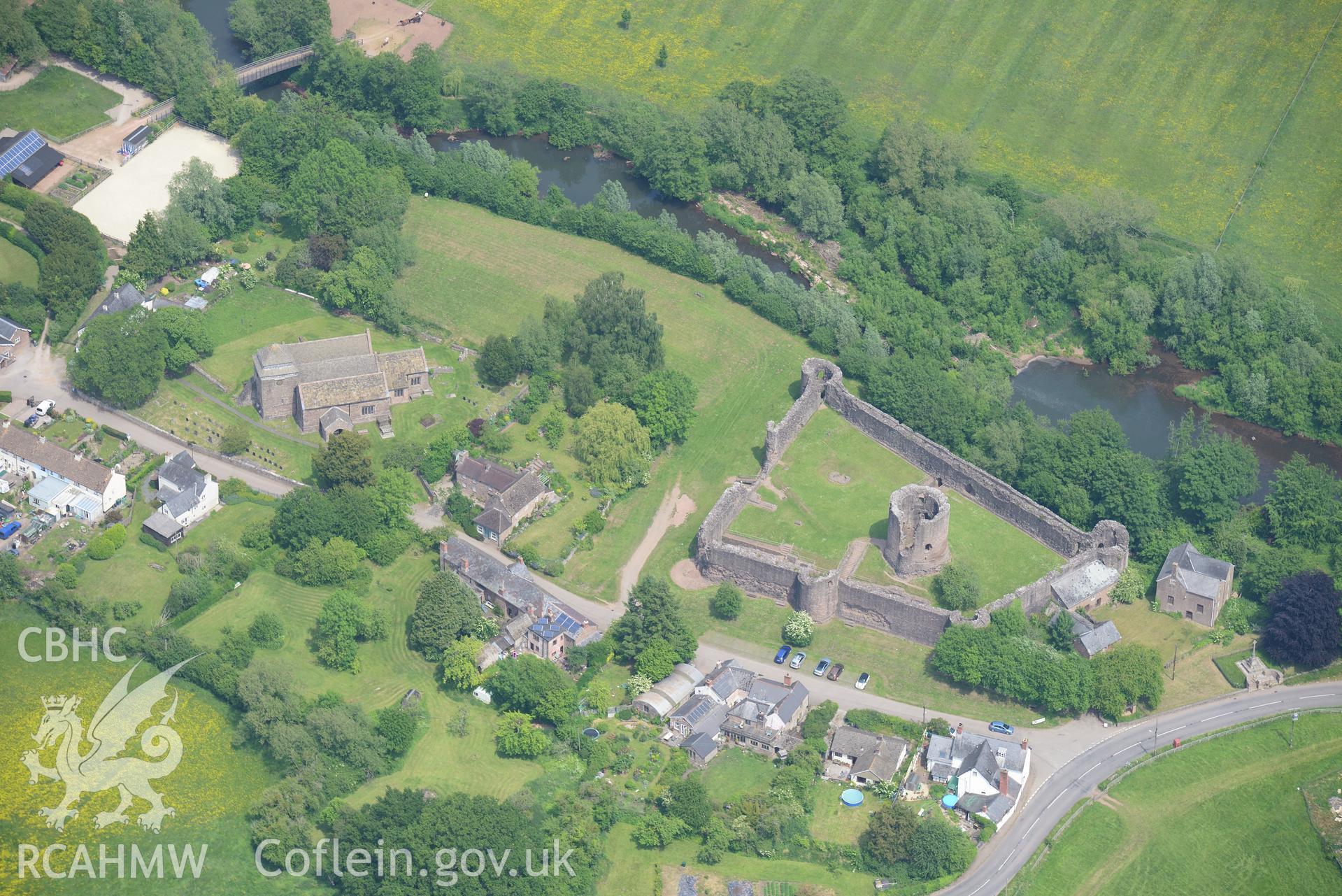 Skenfrith including views of the castle; St. Bridget's Church; bridge; Bell Inn; corn mill and the Old Shop. Oblique aerial photograph taken during the Royal Commission's programme of archaeological aerial reconnaissance by Toby Driver on 11th July 2015.