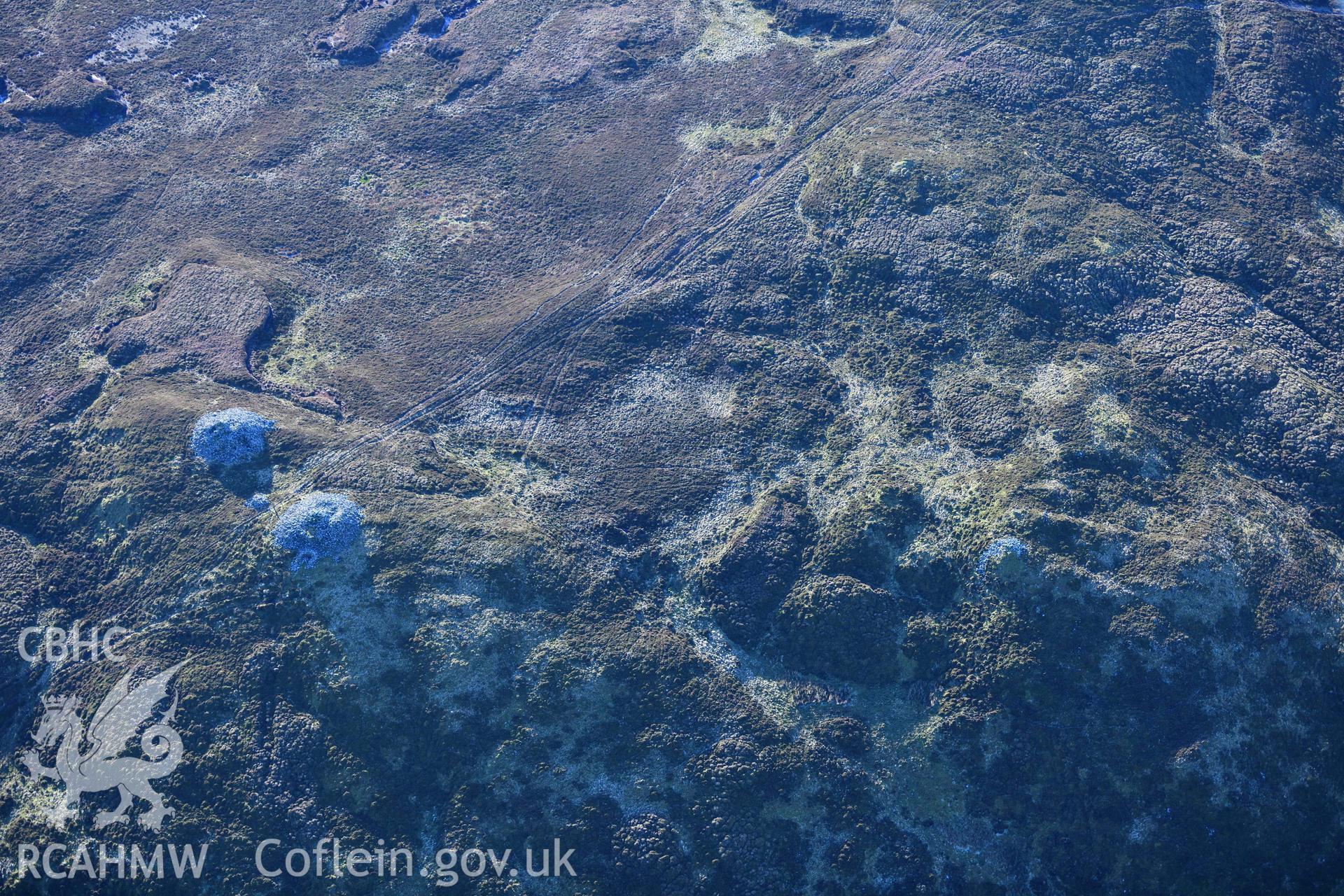 Oblique aerial photograph of cairn pair and outlier at Cairn Biga cairn taken during the Royal Commission’s programme of archaeological aerial reconnaissance by Toby Driver on 17th January 2022