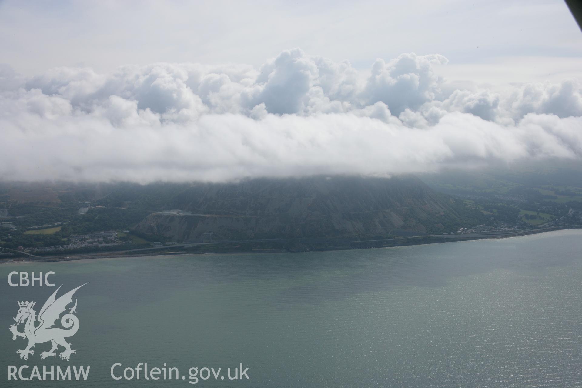 RCAHMW colour oblique aerial photograph of Penmaenmawr Stone Quarry, under cloud, in landscape view from the north. Taken on 14 August 2006 by Toby Driver.