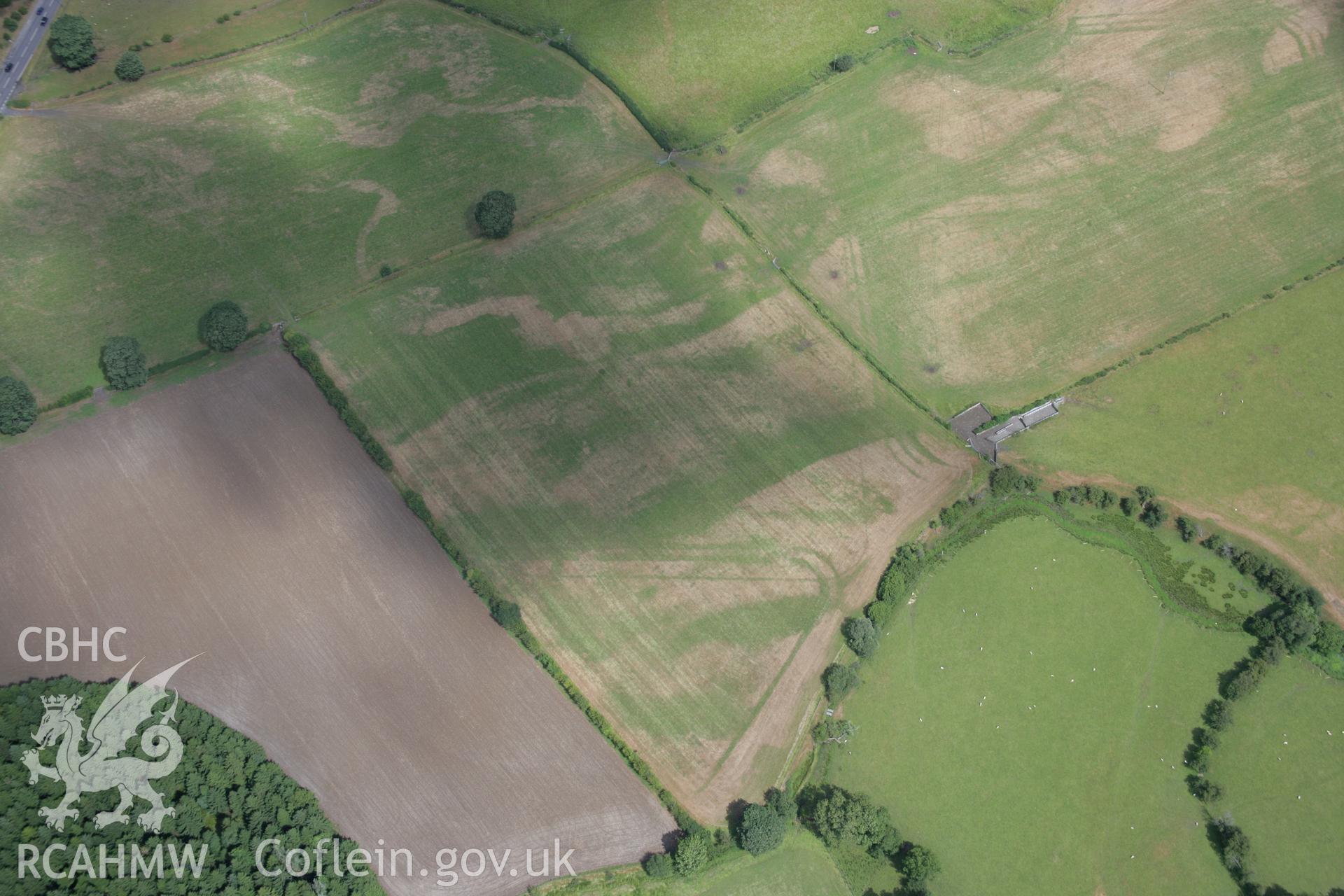 RCAHMW colour oblique aerial photograph of Llanfor Roman Military Complex visible in cropmarks, viewed from the west. Taken on 31 July 2006 by Toby Driver.