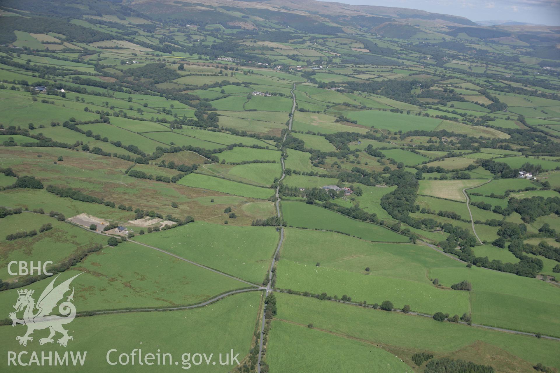 RCAHMW colour oblique aerial photograph of the Roman road from Carmarthen To Castell Collen looking north towards Caerau. Taken on 02 September 2005 by Toby Driver