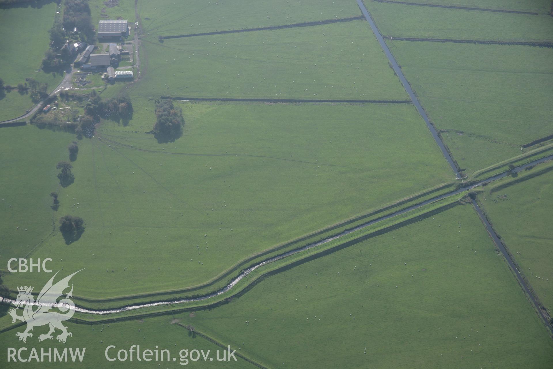 RCAHMW colour oblique aerial photograph of the south-western area of the Bryn-Crug Cropmark Complex from the north-east with faint earthworks in a field to the south of the complex. Taken on 17 October 2005 by Toby Driver
