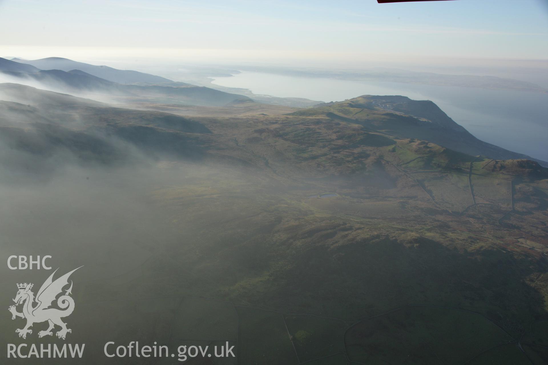 RCAHMW colour oblique aerial photograph of Braich-y-Dinas Hillfort, Penmaenmawr. A winter view of the surrounding upland landscape looking west. Taken on 21 November 2005 by Toby Driver