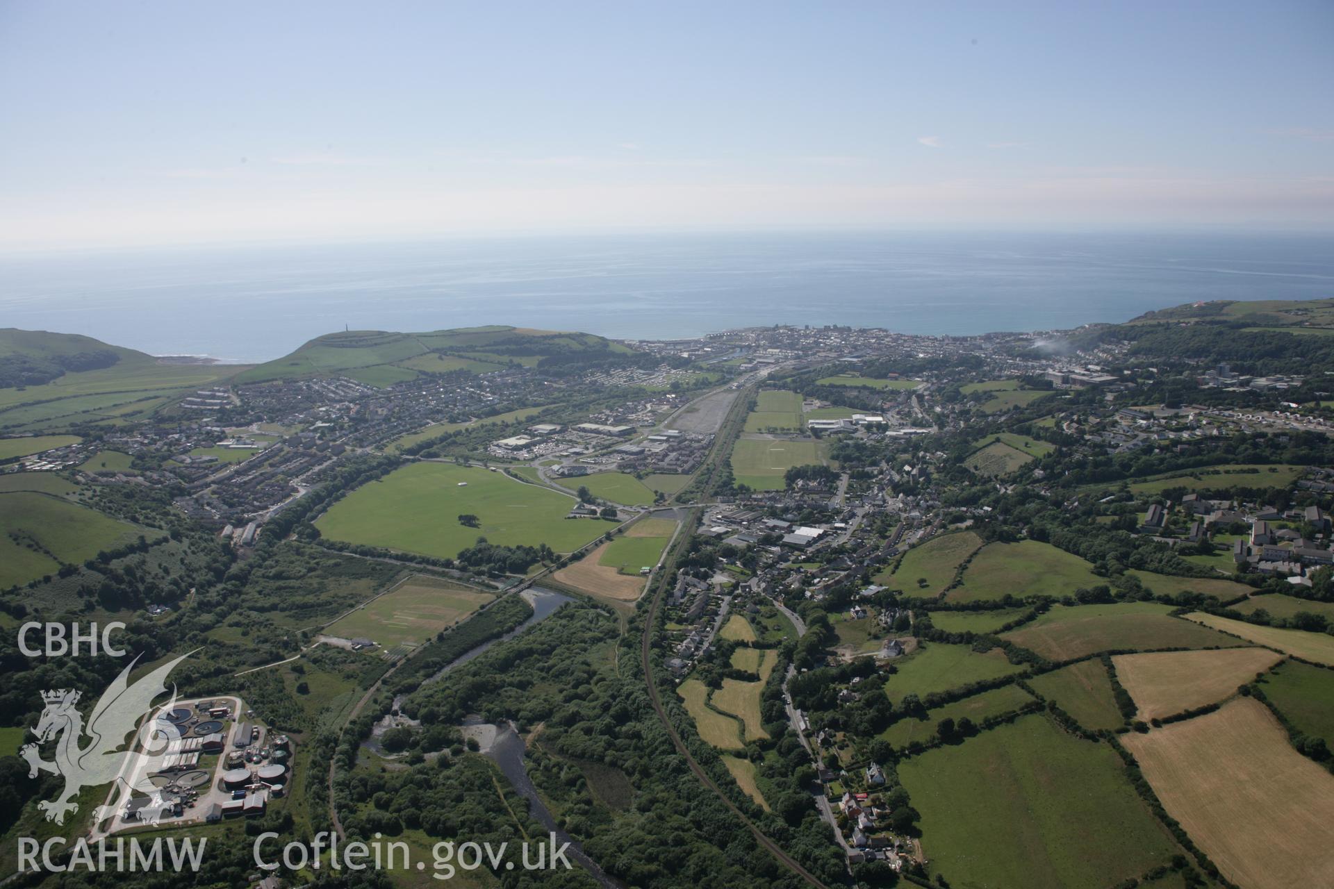 RCAHMW colour oblique aerial photograph of Pen Dinas Hillfort, and town of Aberystwyth, shown in wide view from the east. Taken on 23 June 2005 by Toby Driver