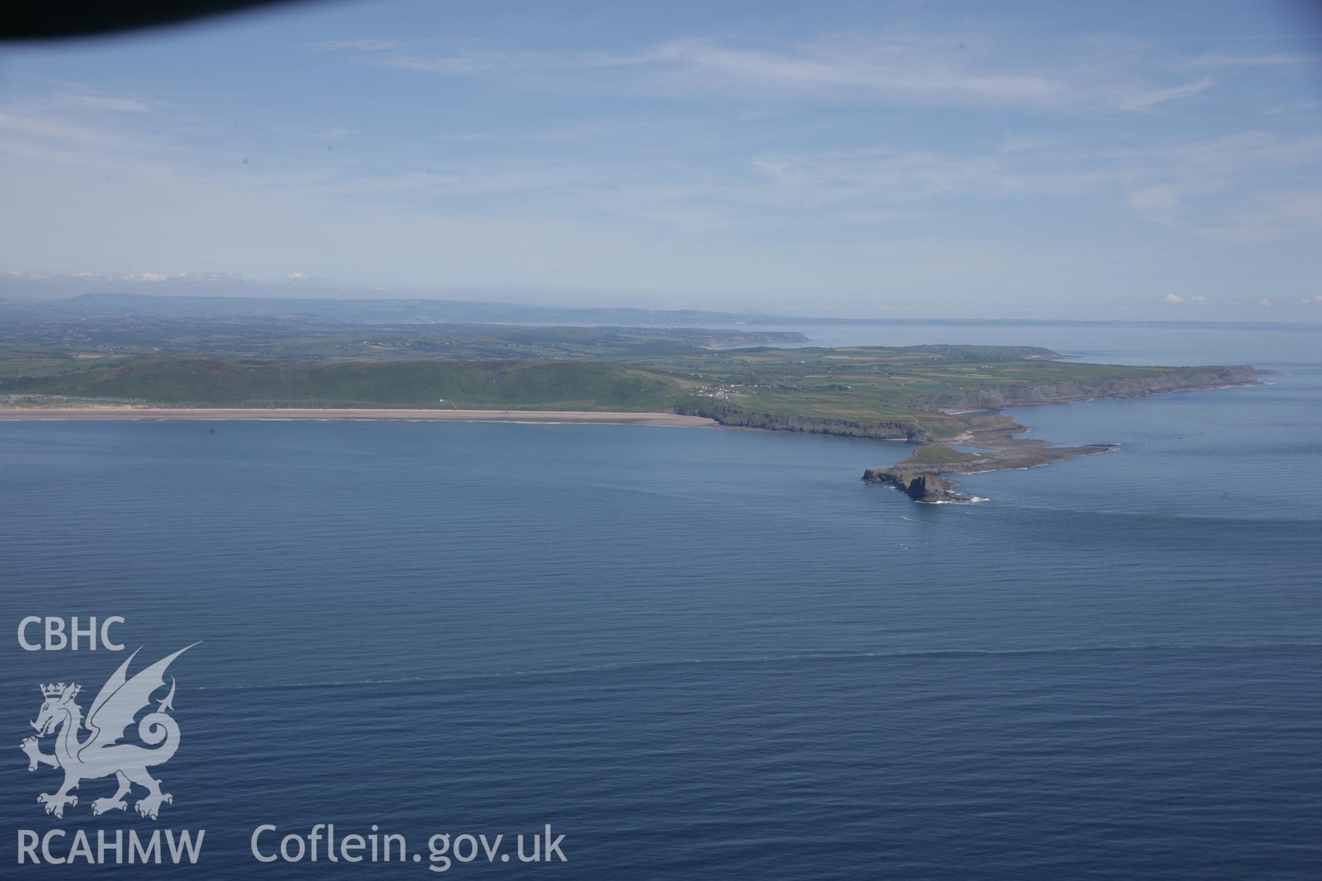 RCAHMW colour oblique aerial photograph of Worms Head Enclosure from the west. A wide landscape view also showing Rhossili Bay. Taken on 22 June 2005 by Toby Driver