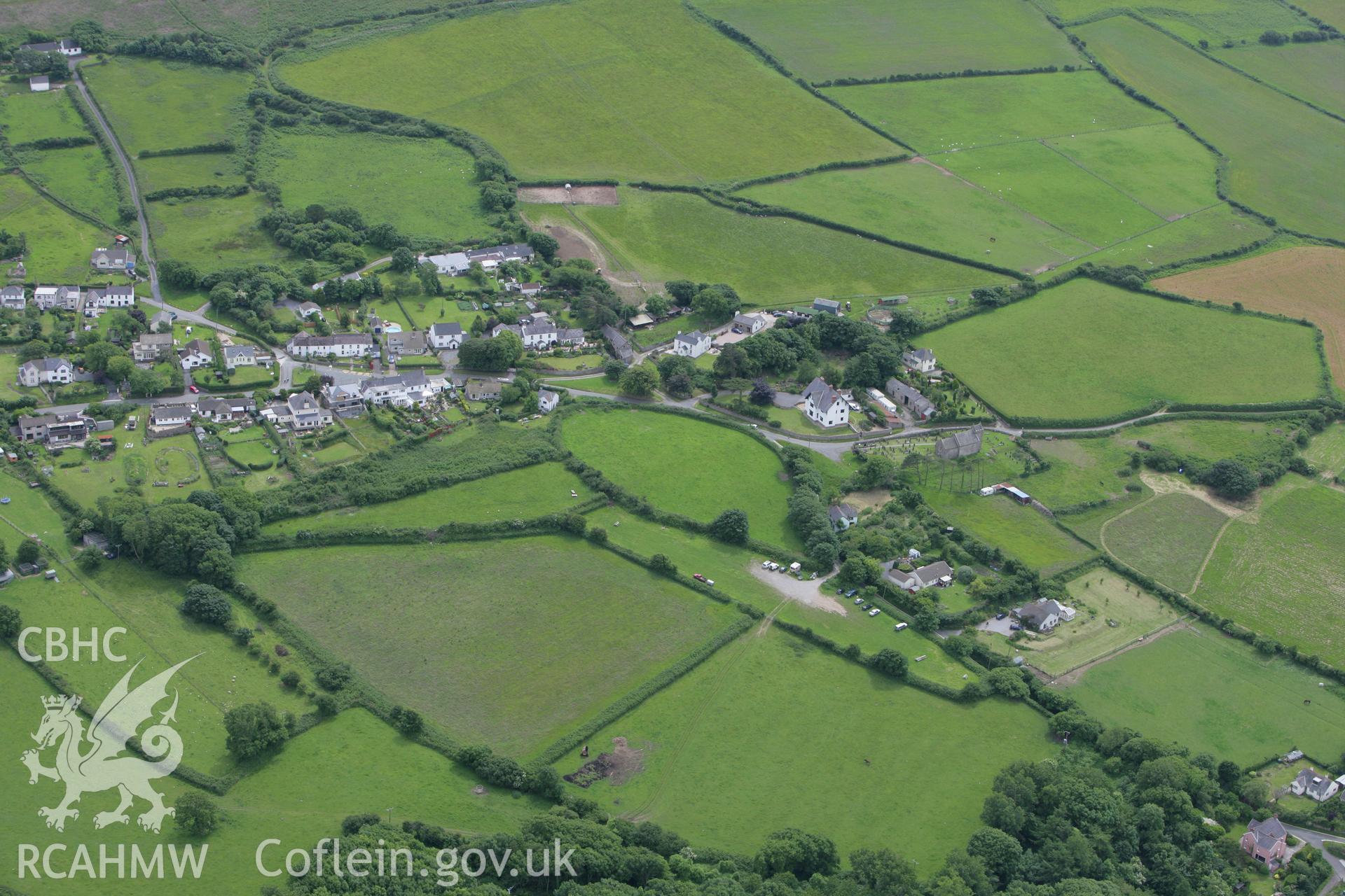 RCAHMW colour oblique photograph of Llandmadog village, with St Madoc's Church. Taken by Toby Driver on 20/06/2008.