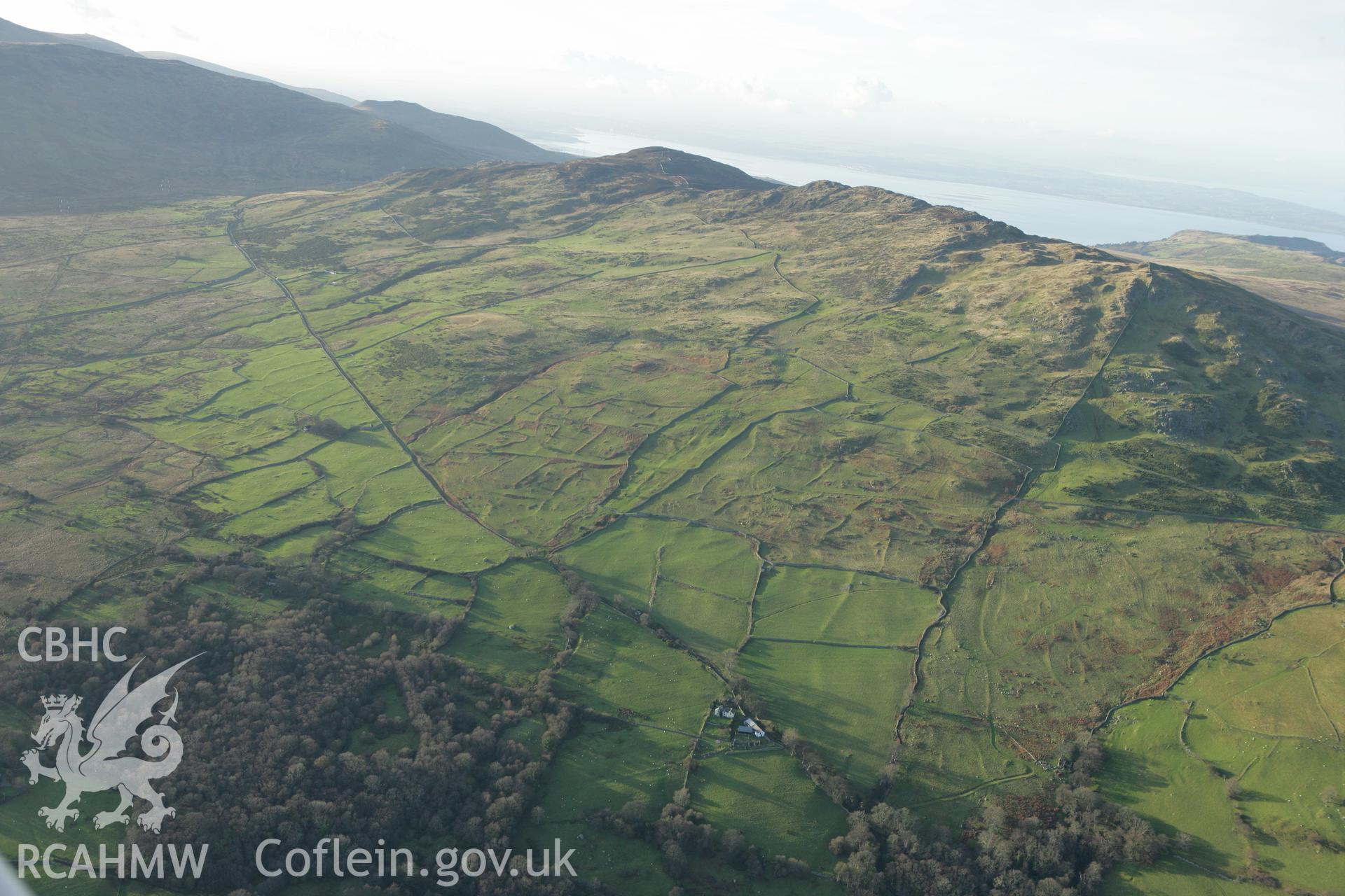 RCAHMW colour oblique aerial photograph of Maen-y-Bardd Settlement and field systems, in landscape from south-east Taken on 10 December 2009 by Toby Driver