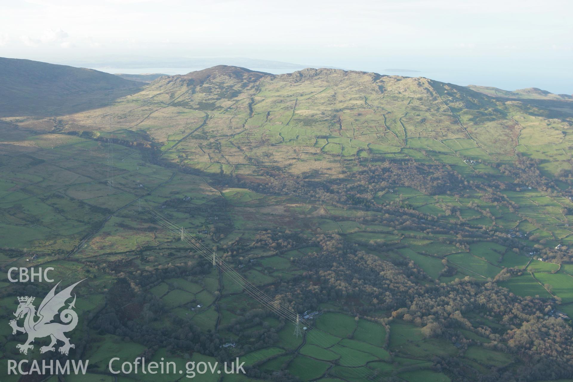 RCAHMW colour oblique aerial photograph of Maen-y-Bardd Settlement and field systems, in landscape from south-east Taken on 10 December 2009 by Toby Driver