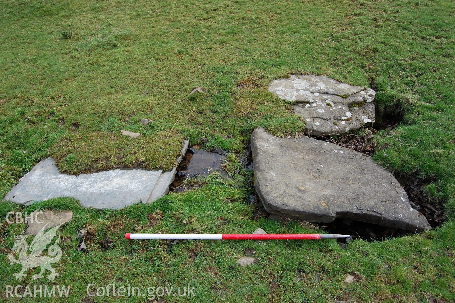 Digital photograph from an archaeological assessment of Deganwy Castle, carried out by Gwynedd Archaeological Trust, 2009. Slabs covering culvert at possible location of tank.