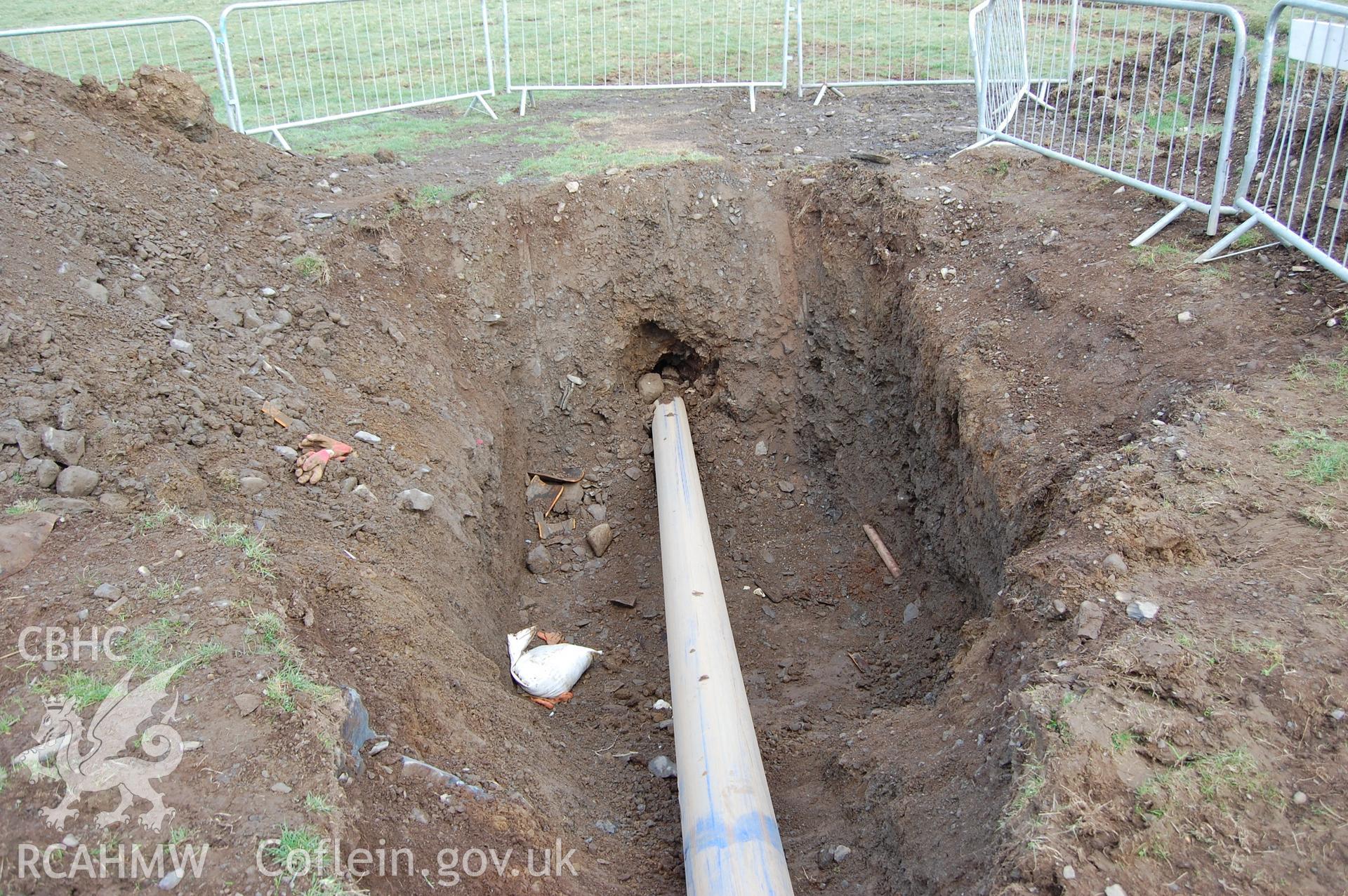 Digitial photograph of pipe bursting hole, from a Gwynedd Archaeological Trust archaeological assessment of a field to the rear of Capel En-gedi, Rhiwgoch, near Harlech.