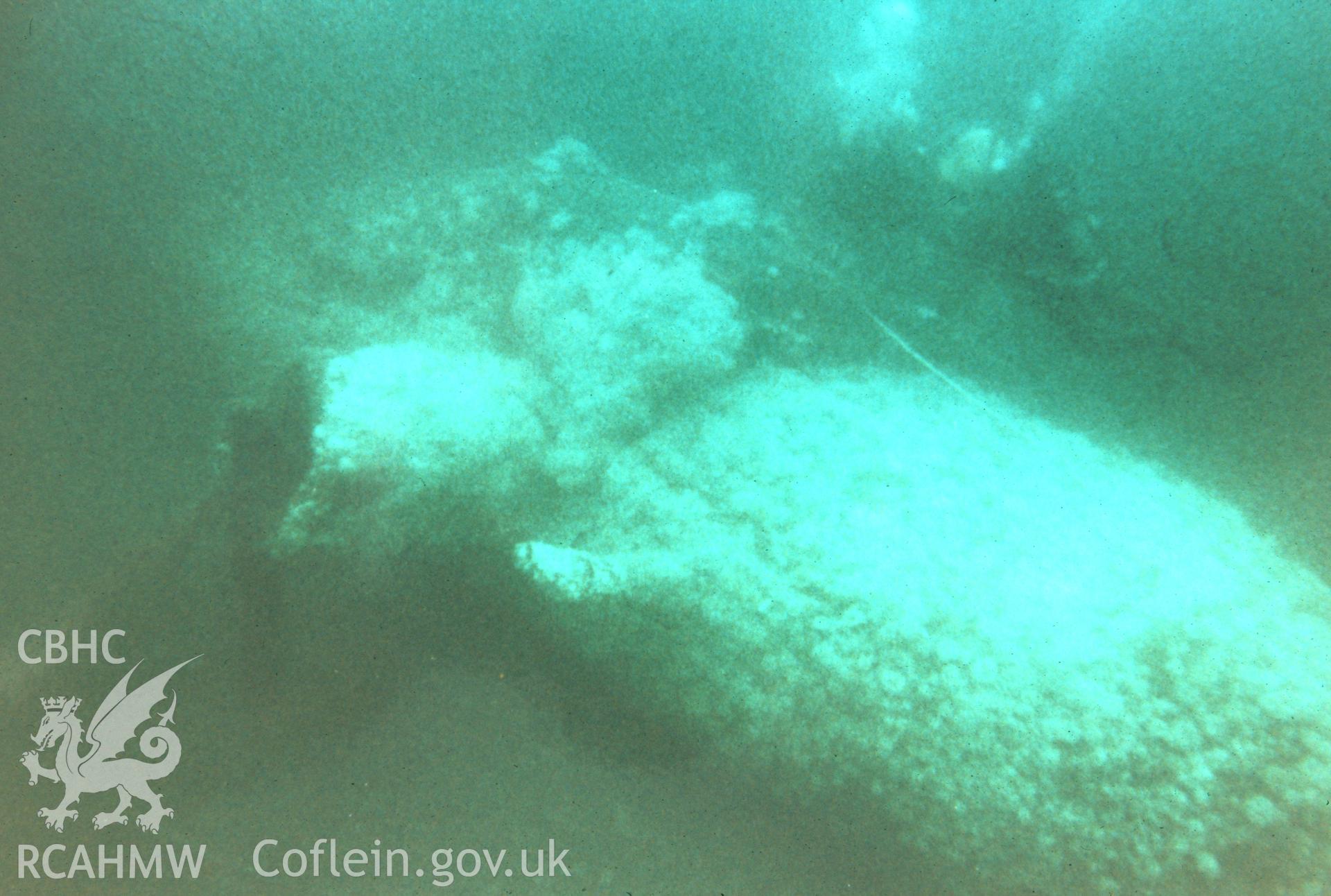 Colour slide. Midsection of submarine (viewed from stern with conning tower and exhaust port) with diver.