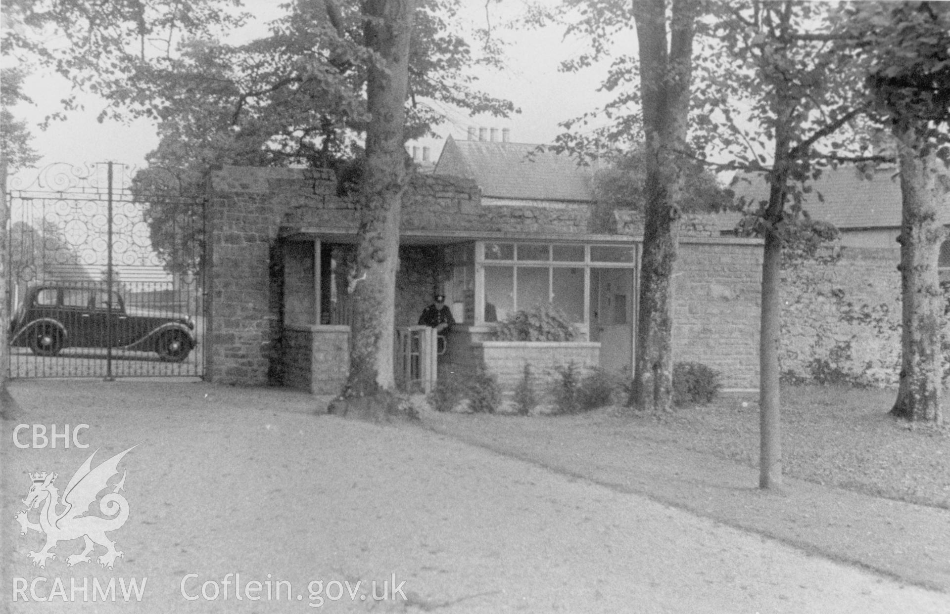 Early view of entrance turnstile to St Fagans Museum with ornate gates and beyond a car.