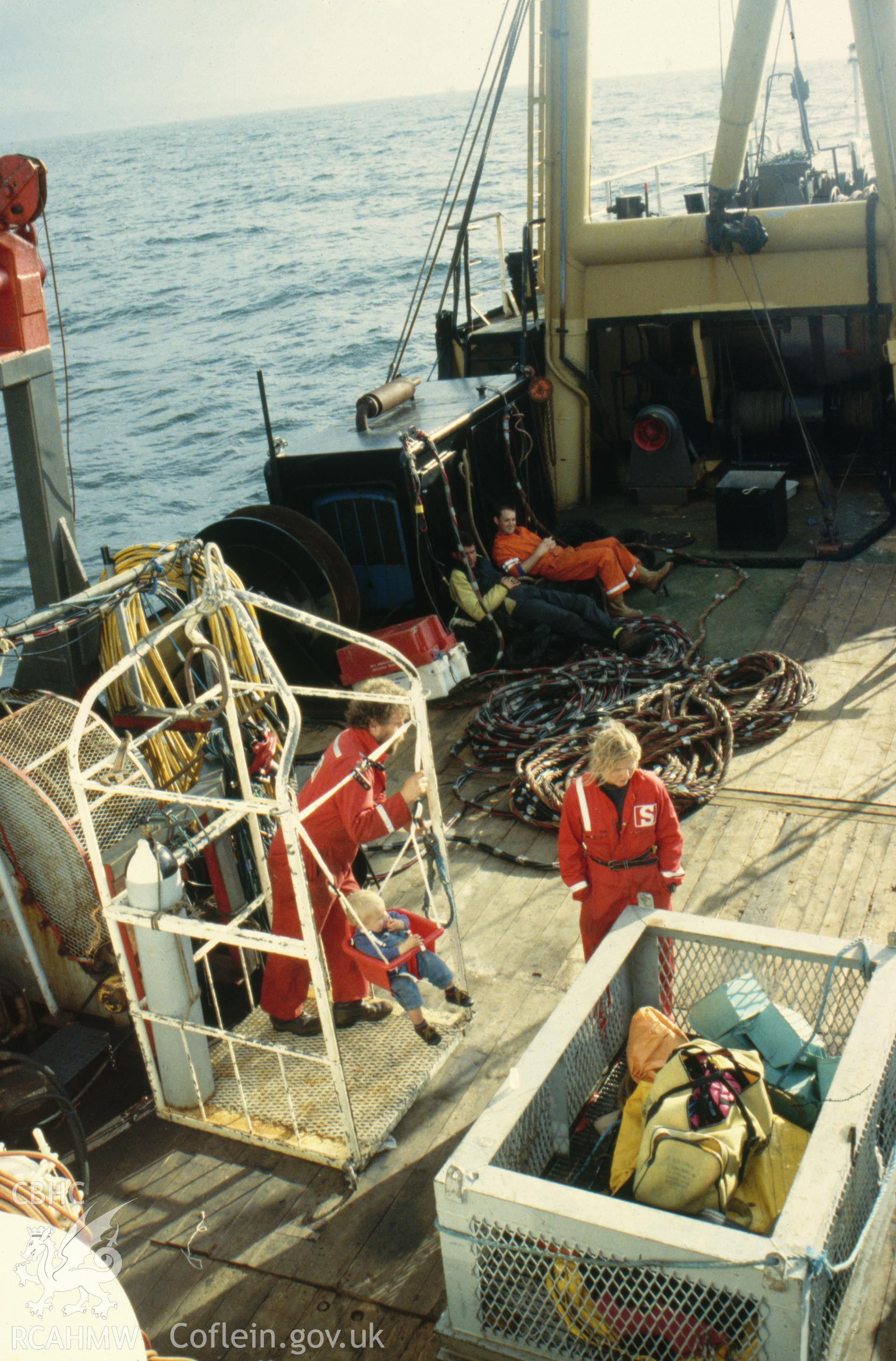 Colour slide. Diver lifting/recovery cage on board research vessel TERSCHELLING with cage for ROVs alongside.