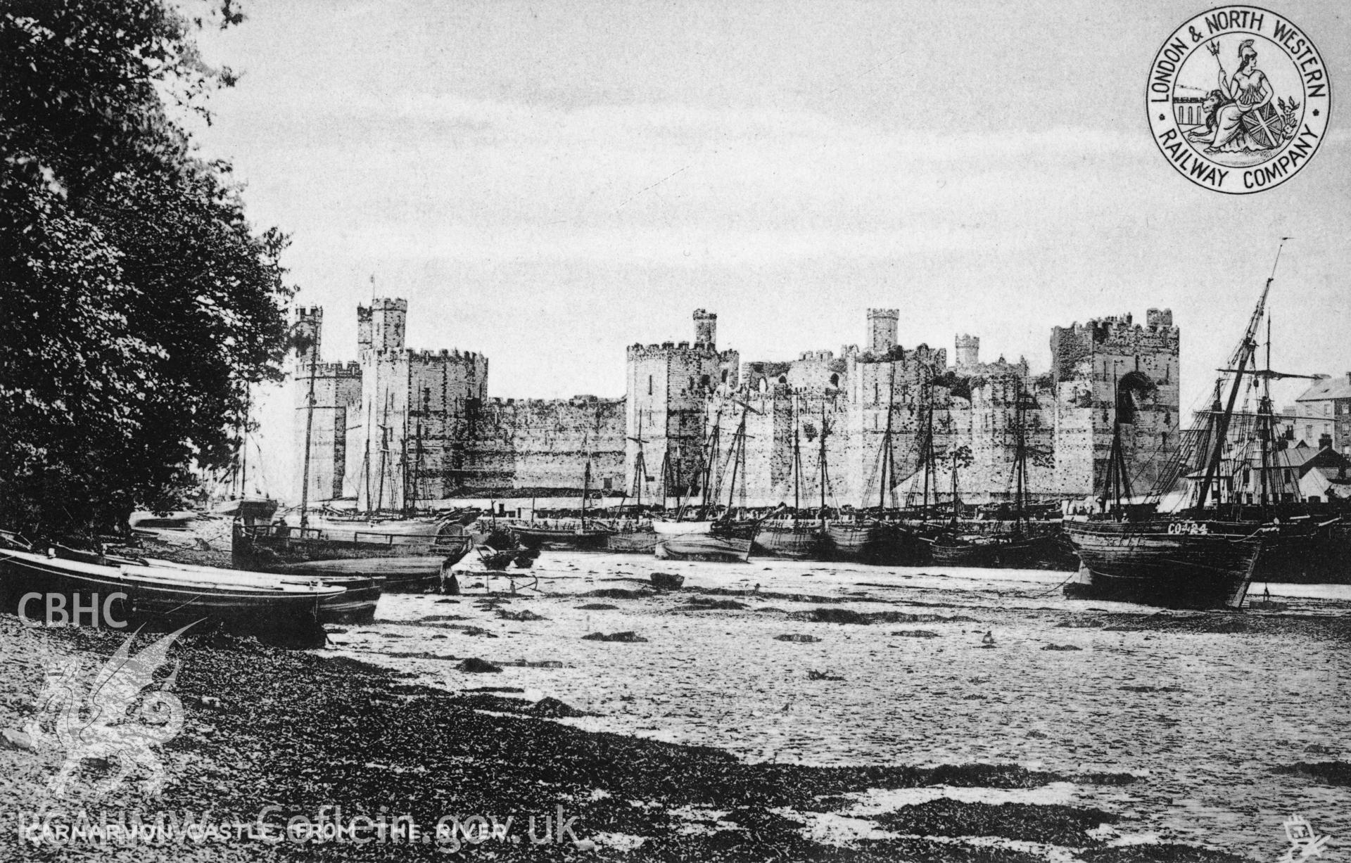 Caernarfon Castle and harbour area, undated black and white photograph showing crane on quayside and three coastal traders.