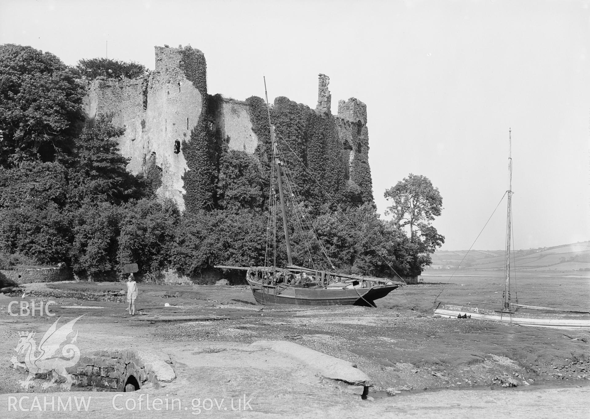 View of Laugharne Castle with boats moored in foreground.