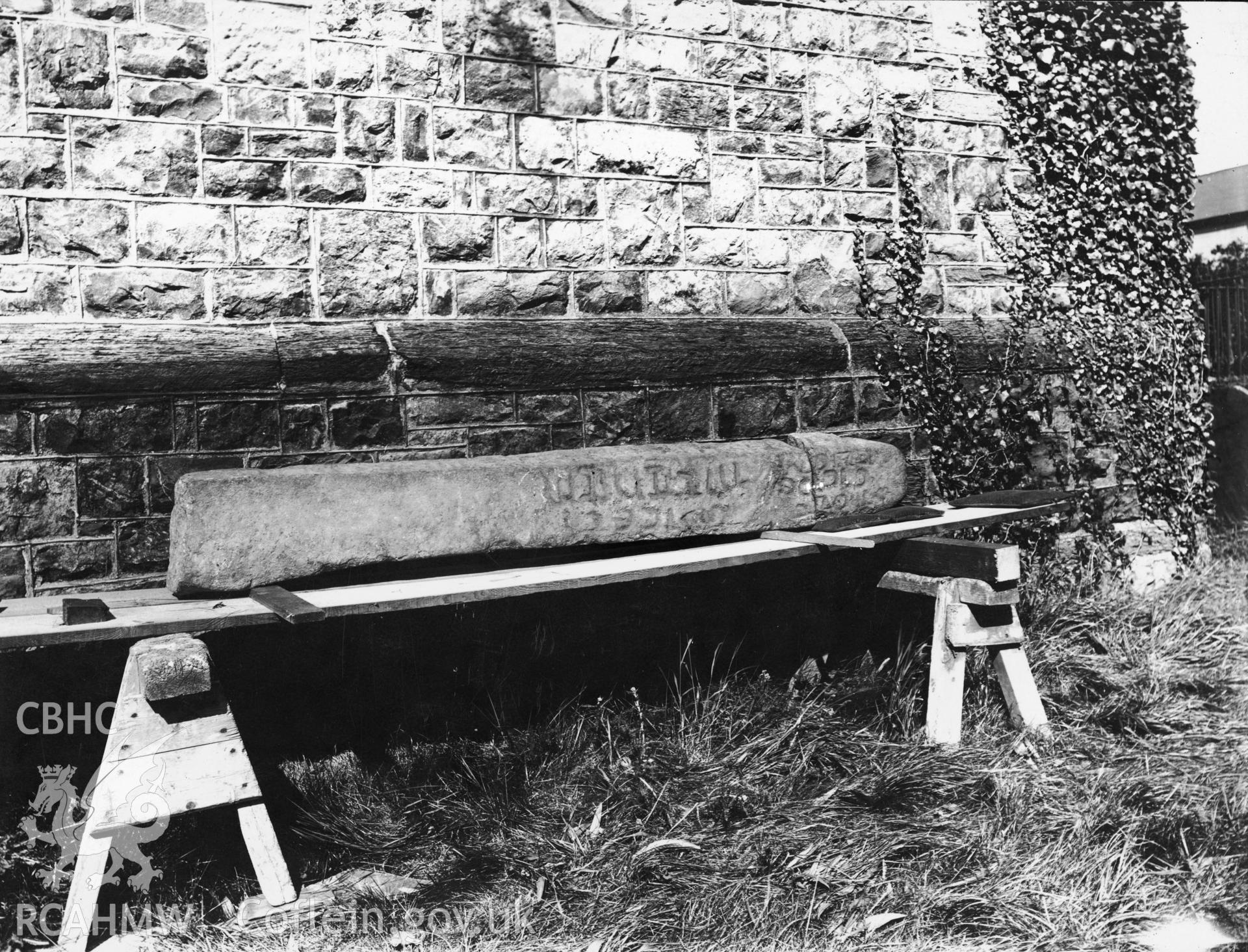 Black and white photographic print of inscribed stone at ST Cadfan's, Towyn, from a collection produced or collected by former RCAHMW investigator W.E. Griffiths. Undated, photographer unknown.
