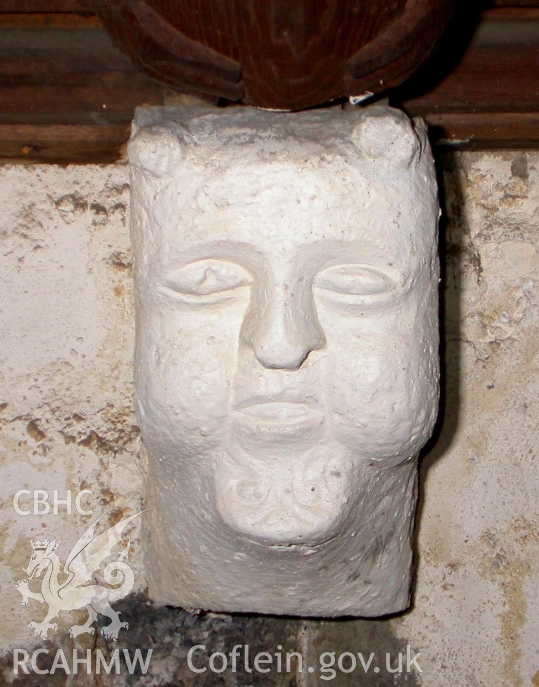 Carved stone head between Trusses IV & V, South side.