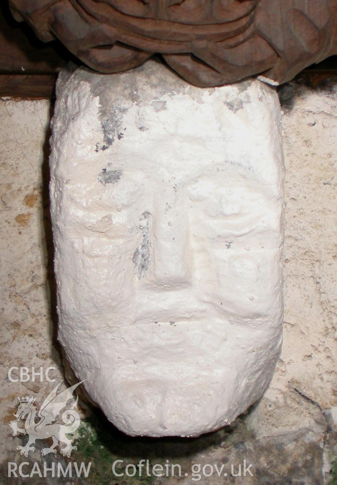 Carved stone head between Trusses I & II, south side.