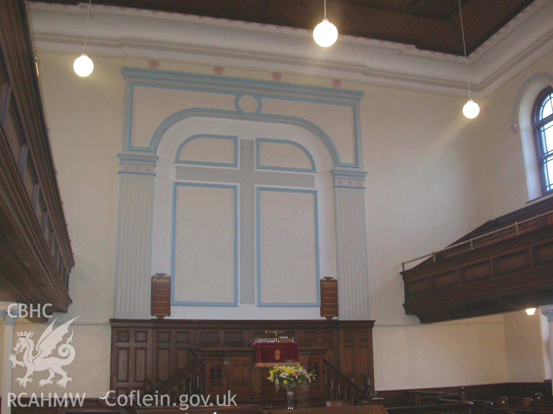 North-east rear wall of 1899 chapel with pulpit and cross on rear wall.