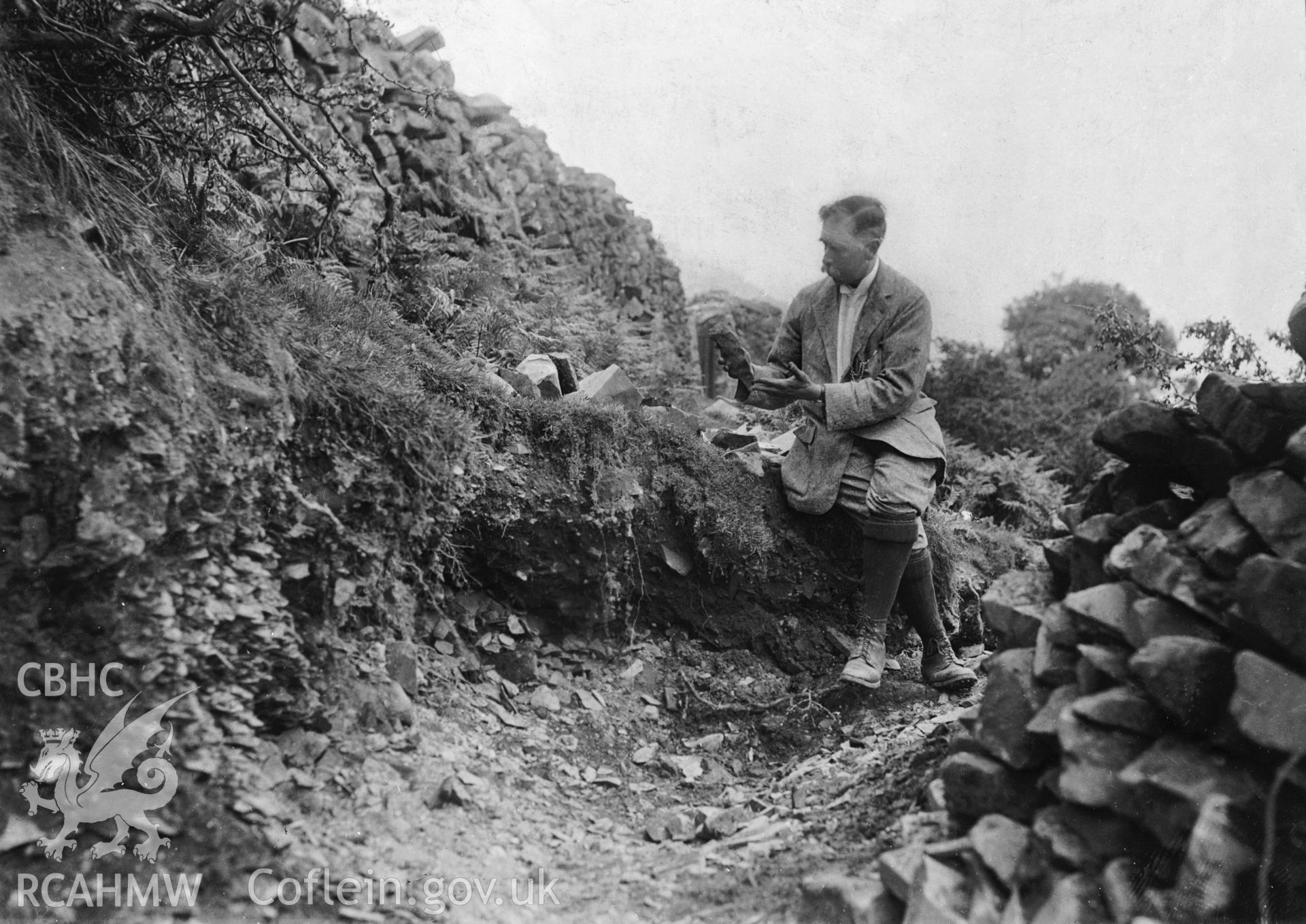 Black and white photograph showing Mr Hazzeldine Waren at the Graiglwyd axe chipping site taken during the 1919-1921 excavations, copied from an original loaned for copying by Ivor Davies.
