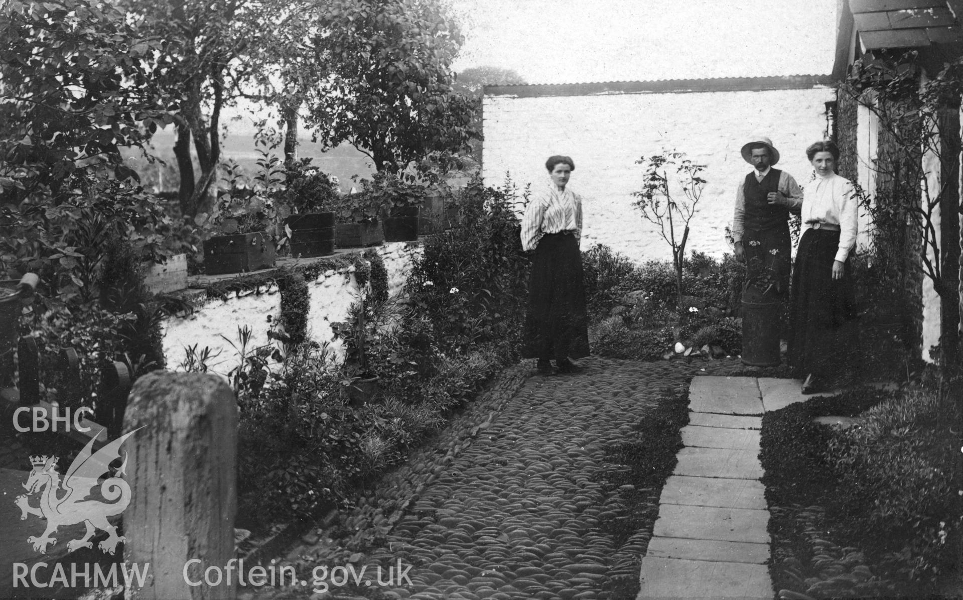 Postcard showing front entrance of Ynysywern Farm with John Evan, Gwen and Ellen Morgan. Dated between 1902 and 1910.