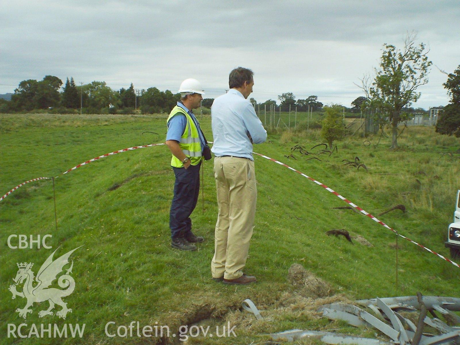 Colour digital photograph showing workmen inspecting a demolished mast.