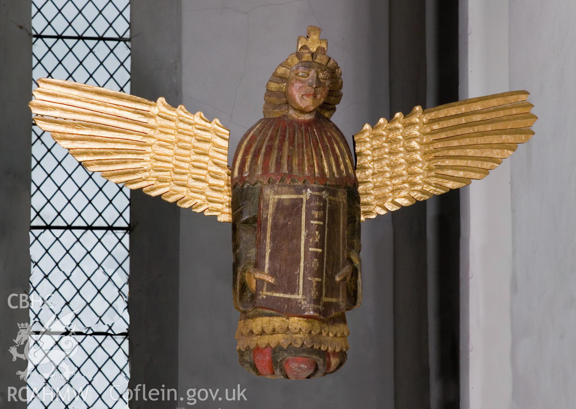 Carved and painted wooden angel effigy.