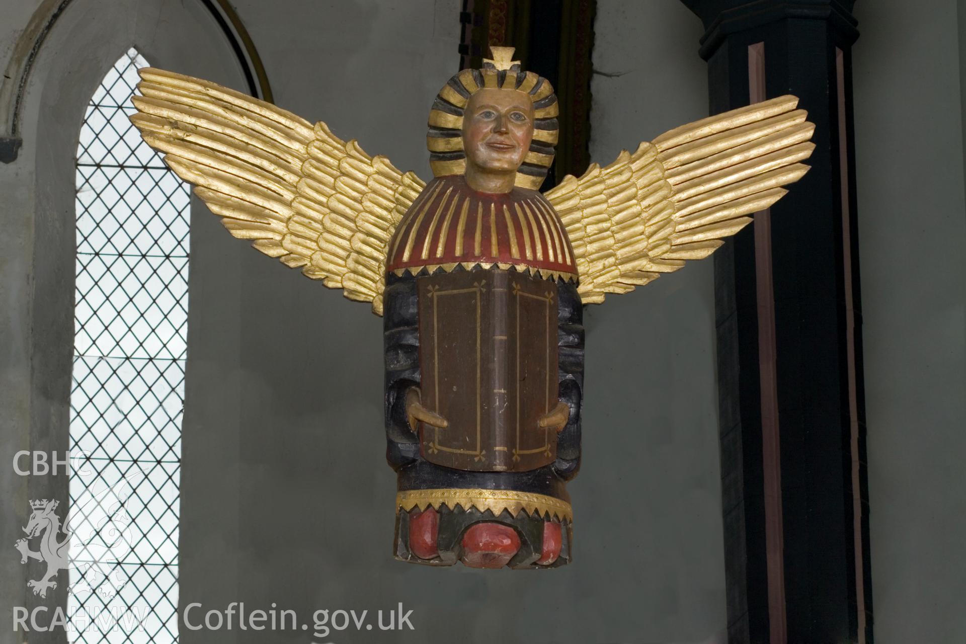 Carved and painted wooden angel effigy.