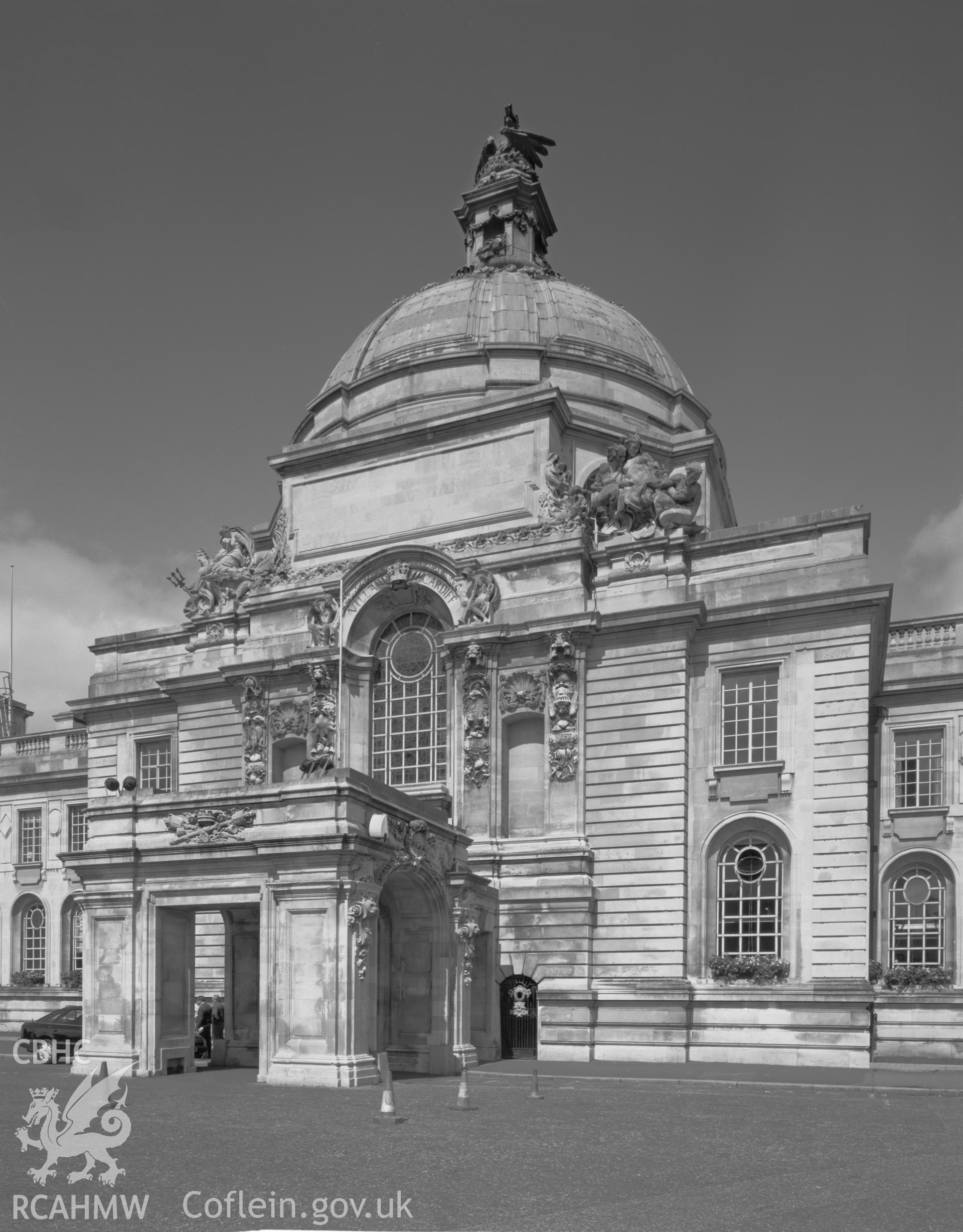 Black and white print of exterior of City Hall, Cardiff. Negative held.