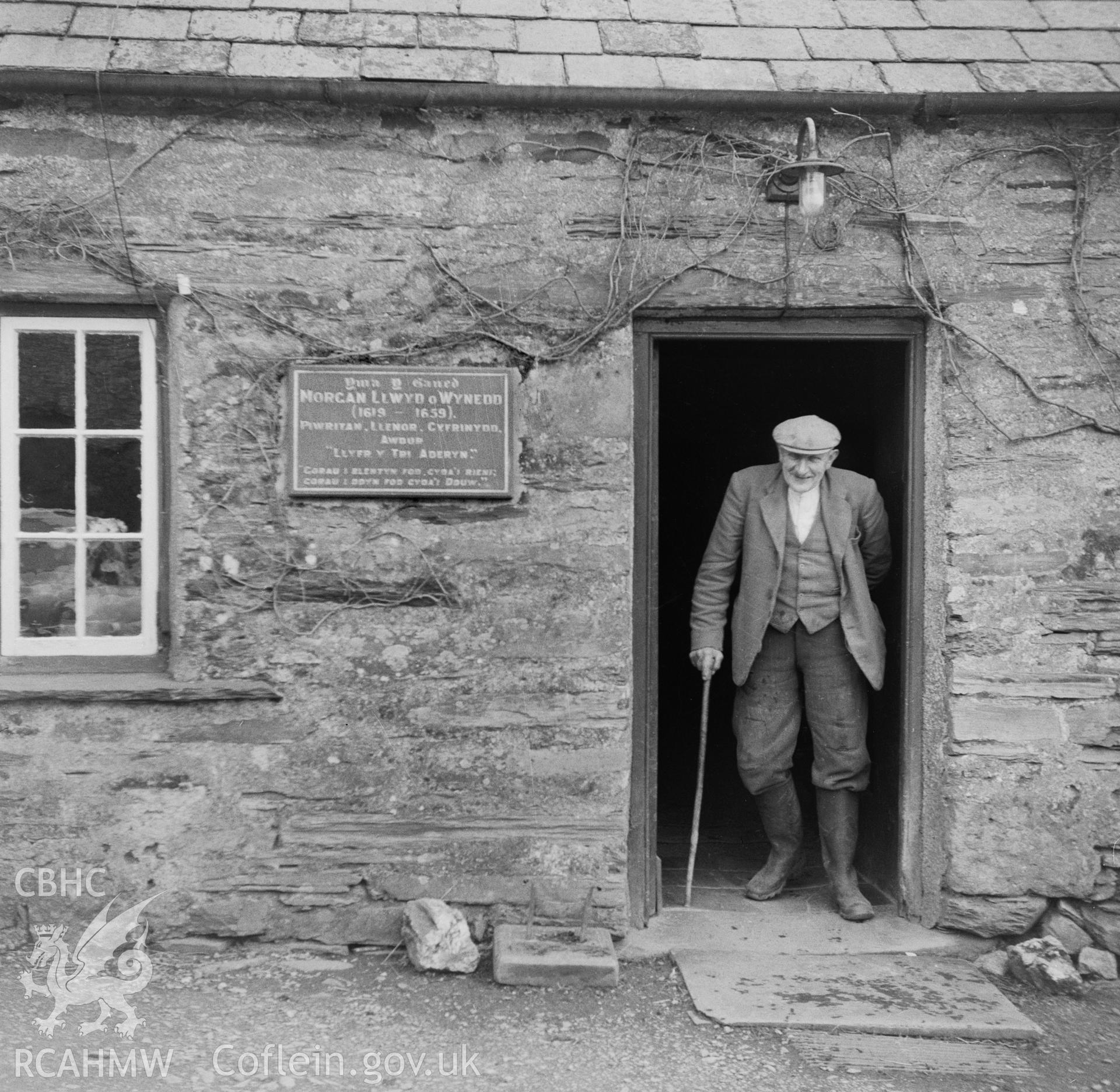 View showing the doorway and inscription, with a figure standing in the doorway