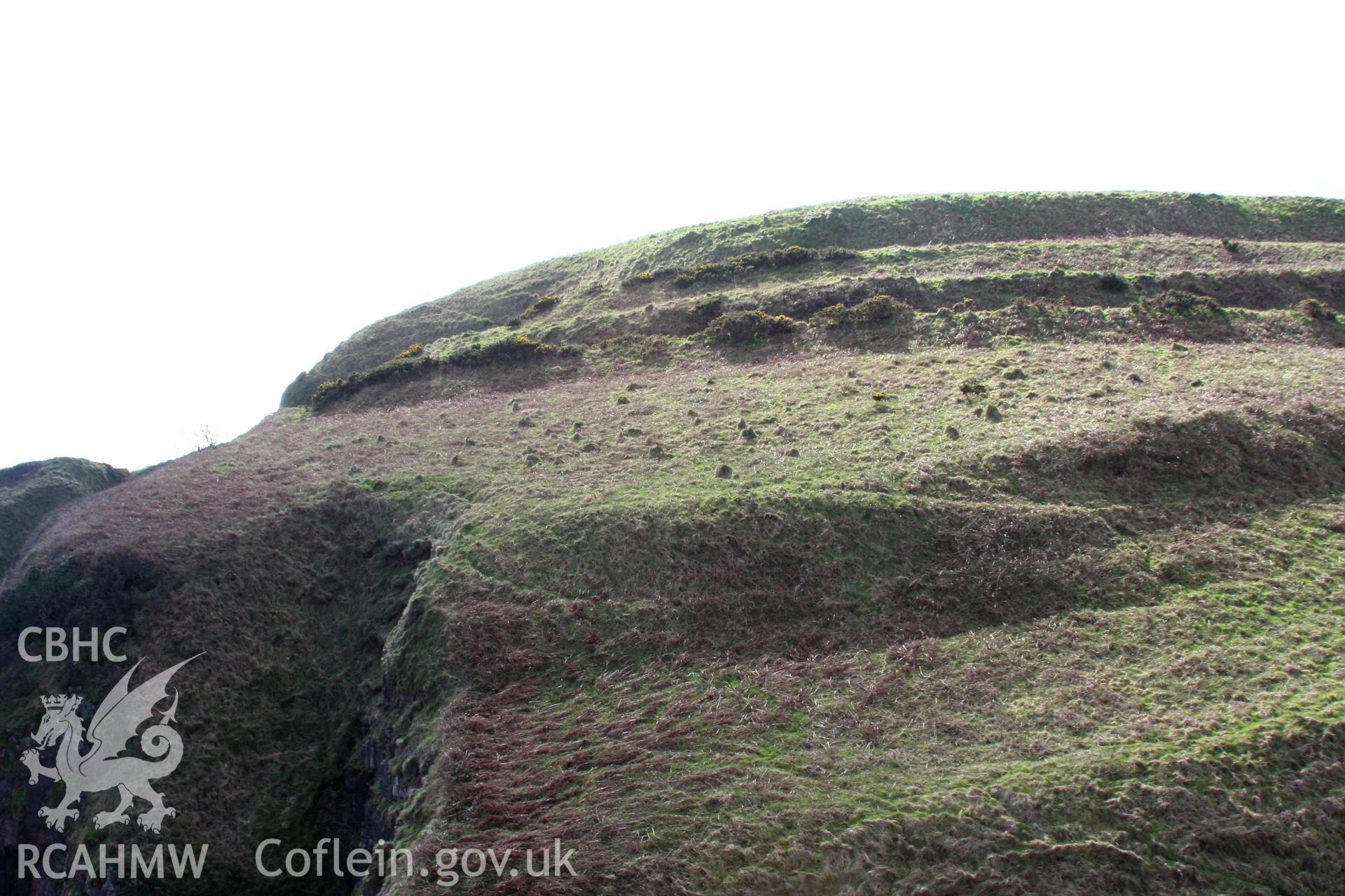 Looking south to the rampart defining the outer enclosure and its oblique entrance approach.