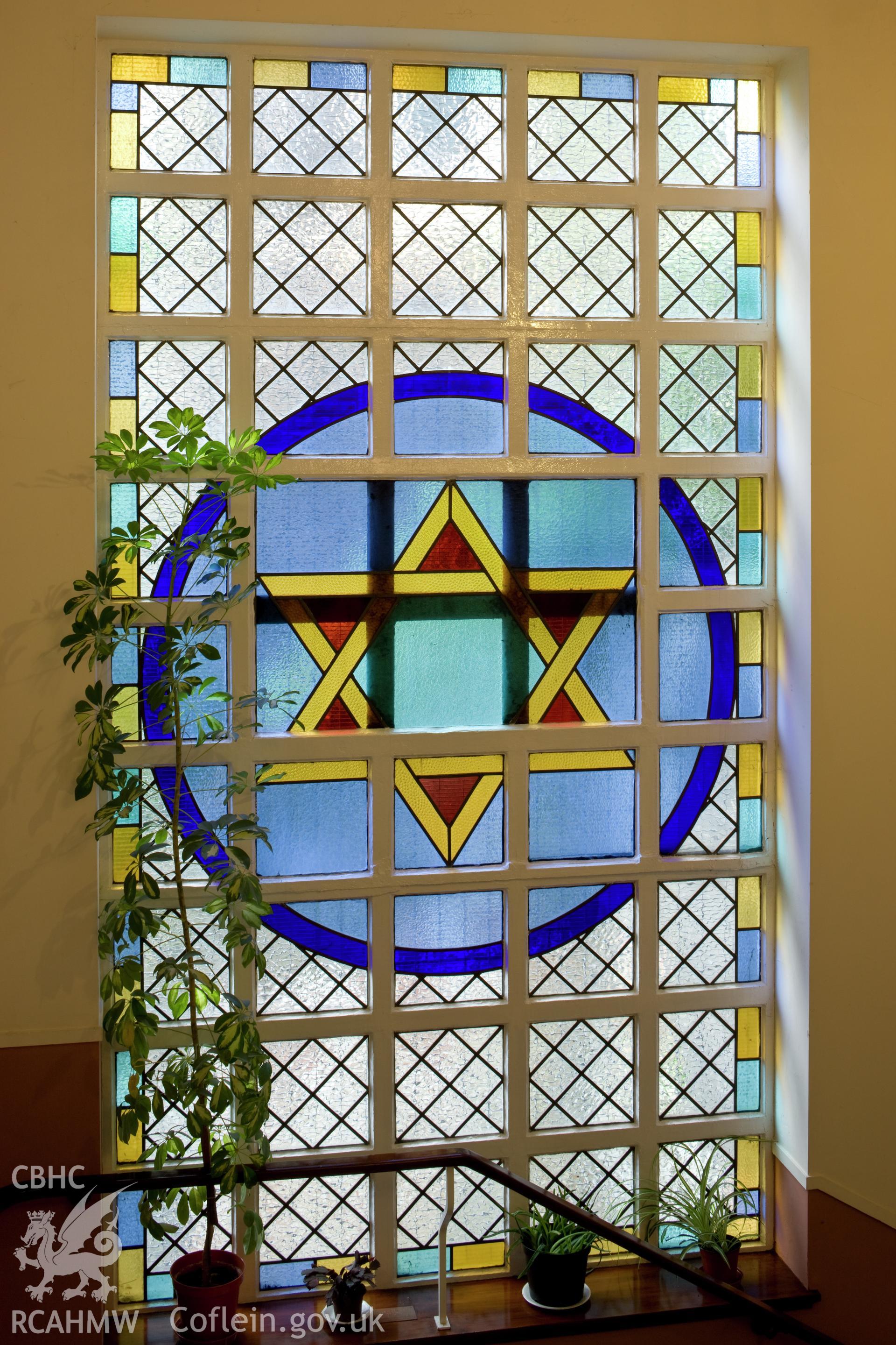 Star of David stained glass window on stair.