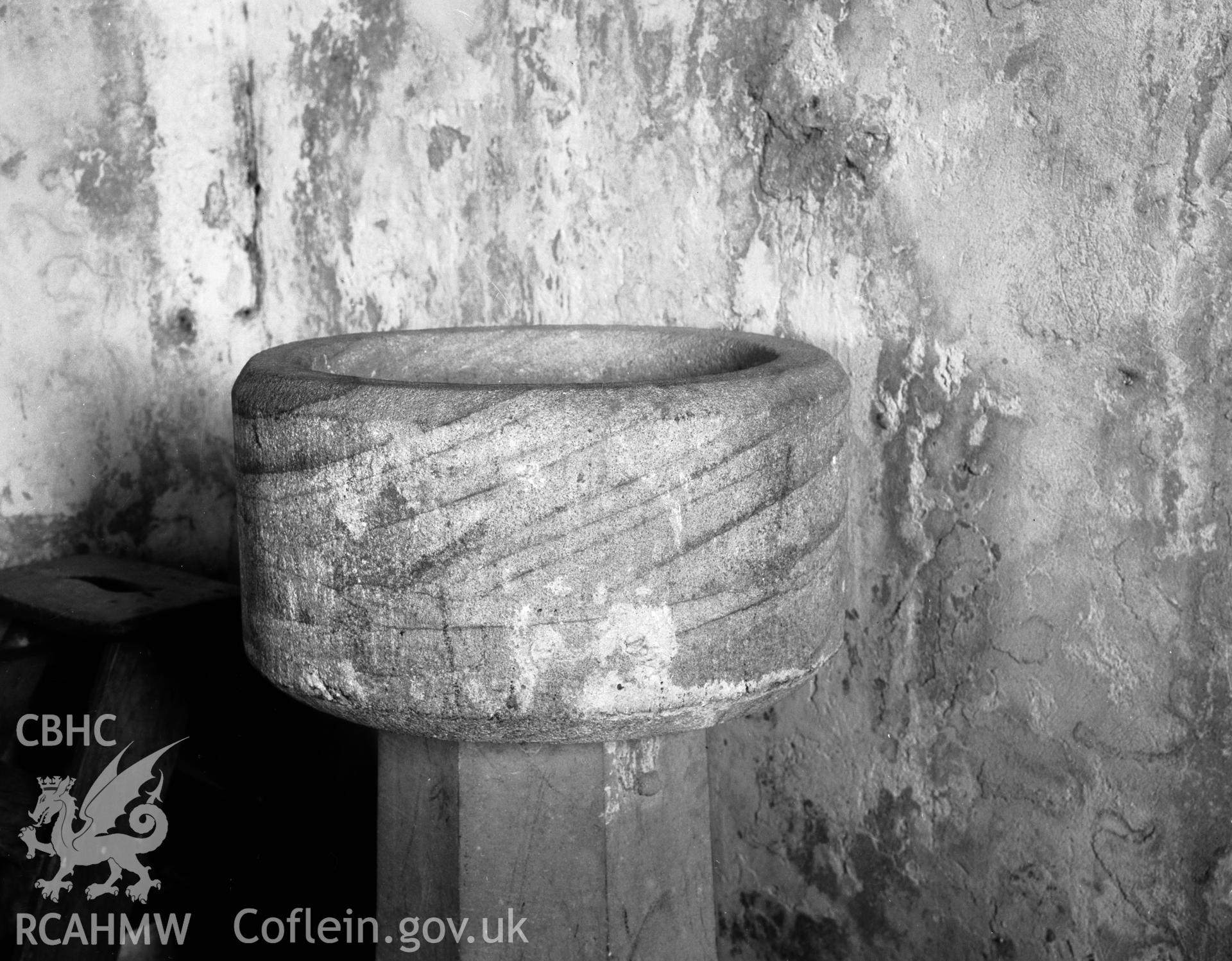Black and white photograph of the font at St Enghenedl's Church, Llanynghenedl.