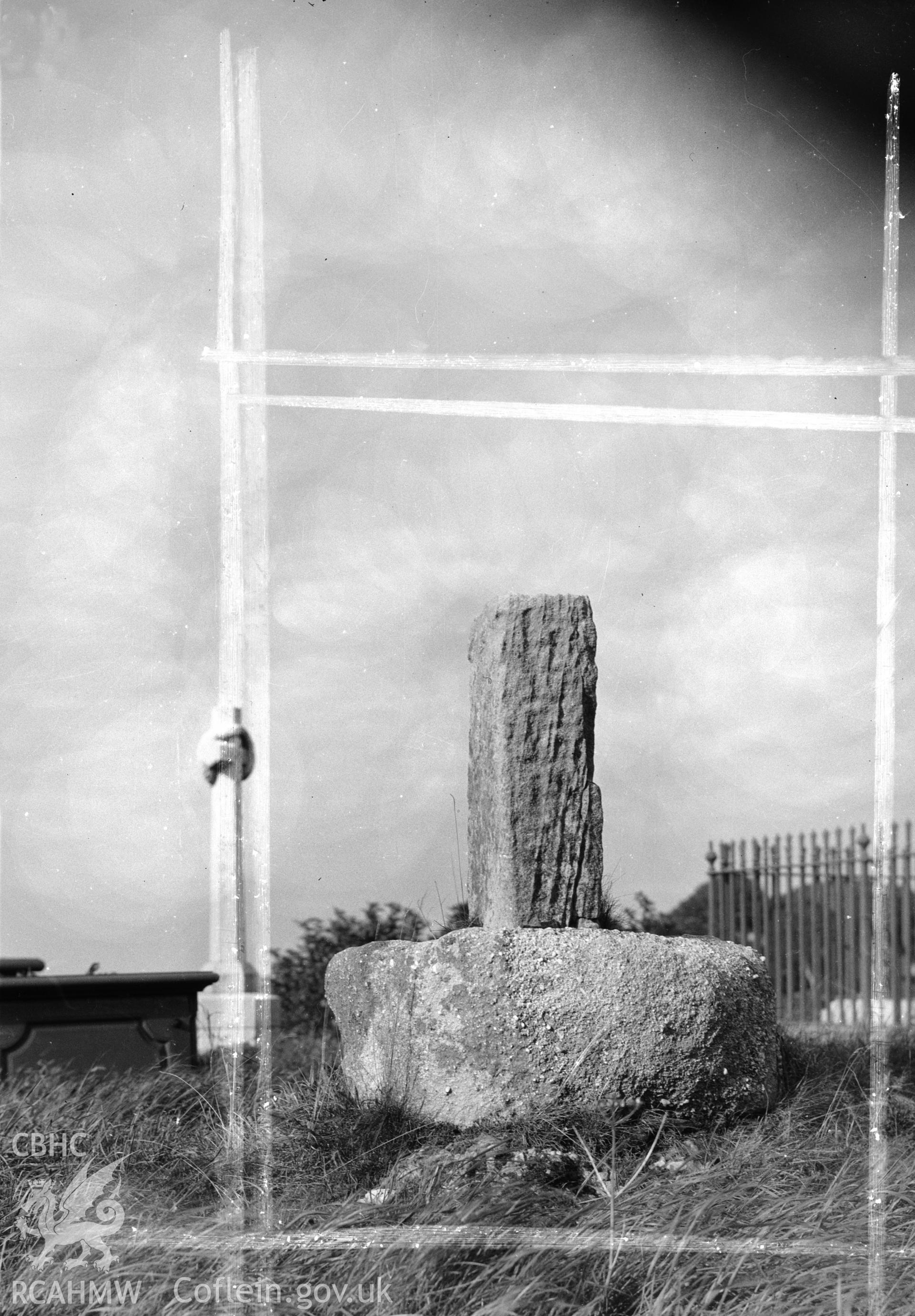 One black and white photograph showing the south face of t the crosss base in St Caffo's Churchyard.