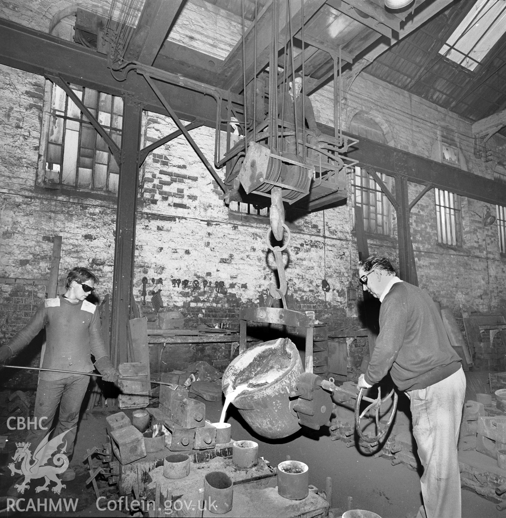 The ladle, moved by gantry, is being tilted manually for pouring
