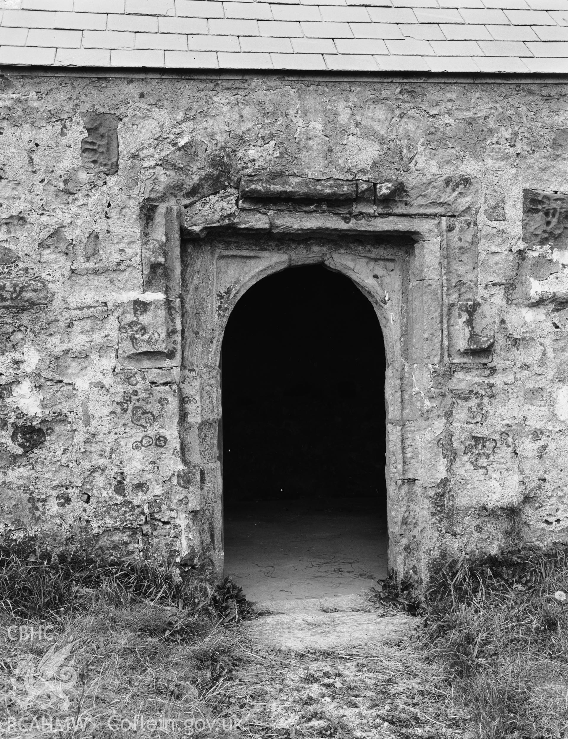 Digitised copy of a black and white negative showing fifteenth-century south doorway at St Cwyfan's Church, produced by RCAHMW before 1960