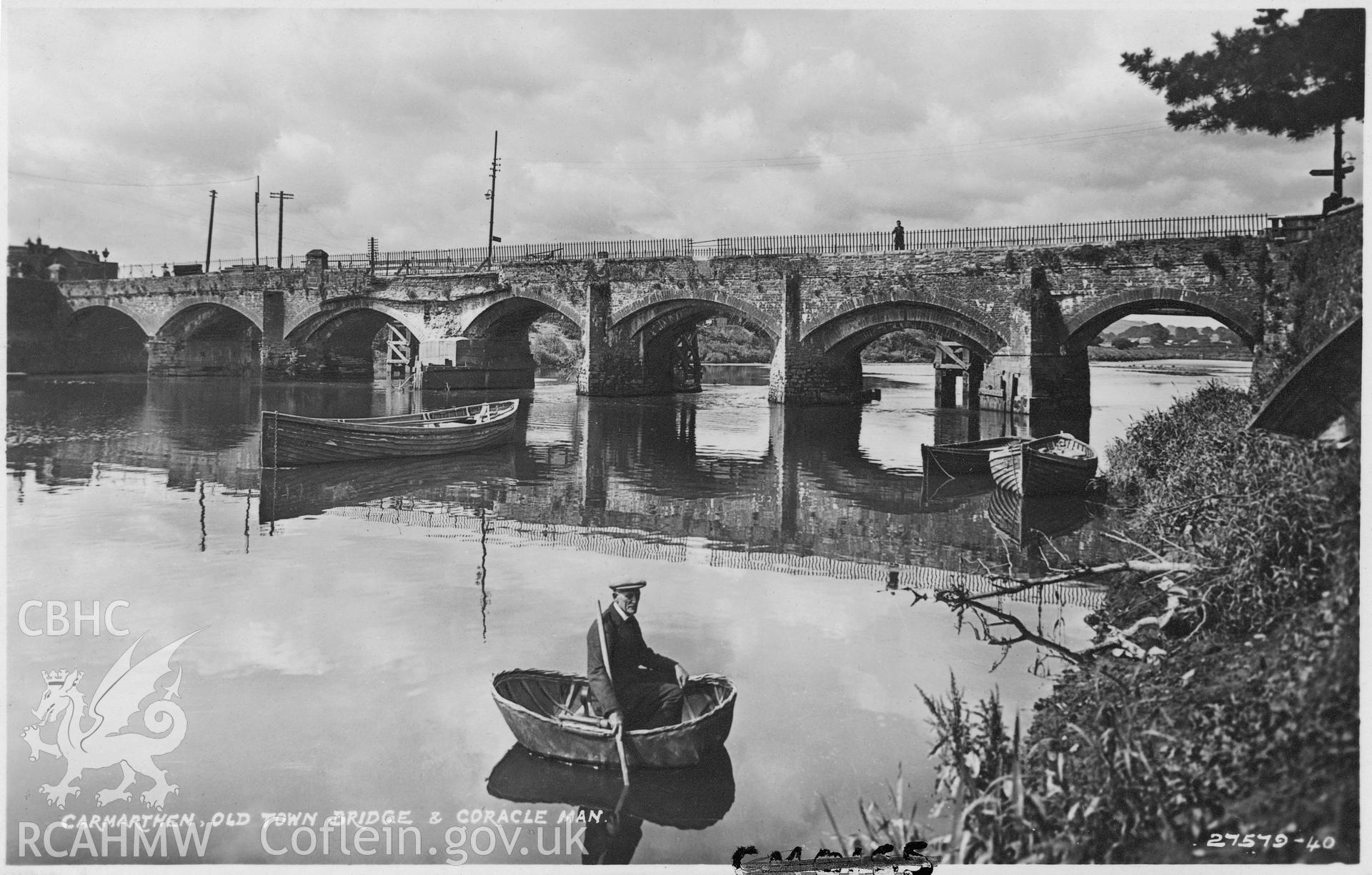 Black and white postcard showing Carmarthen Bridge with a manned coracle in the foreground.