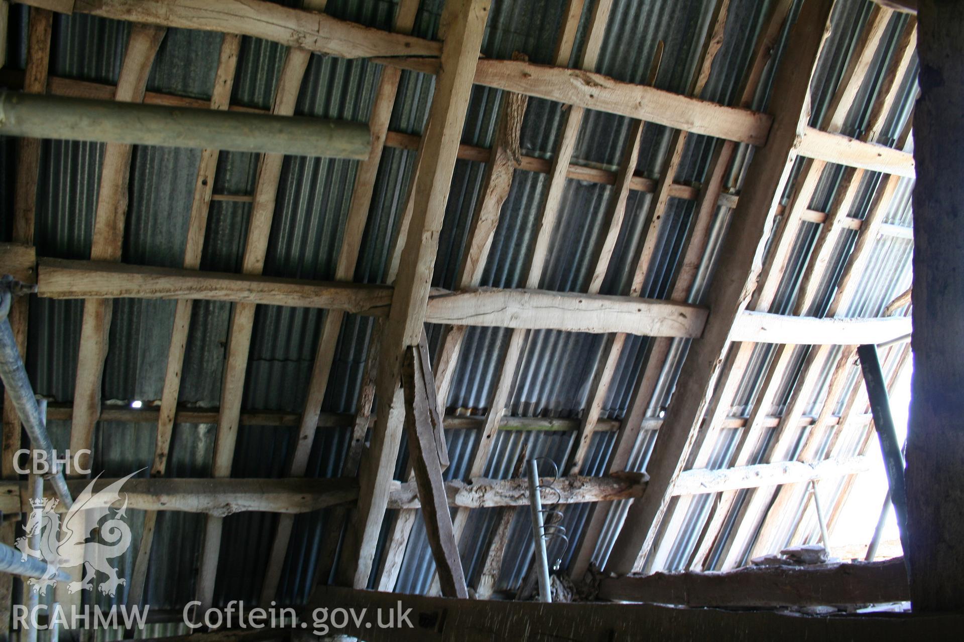 Interior trusses and timbers to stone walled barn at east end.