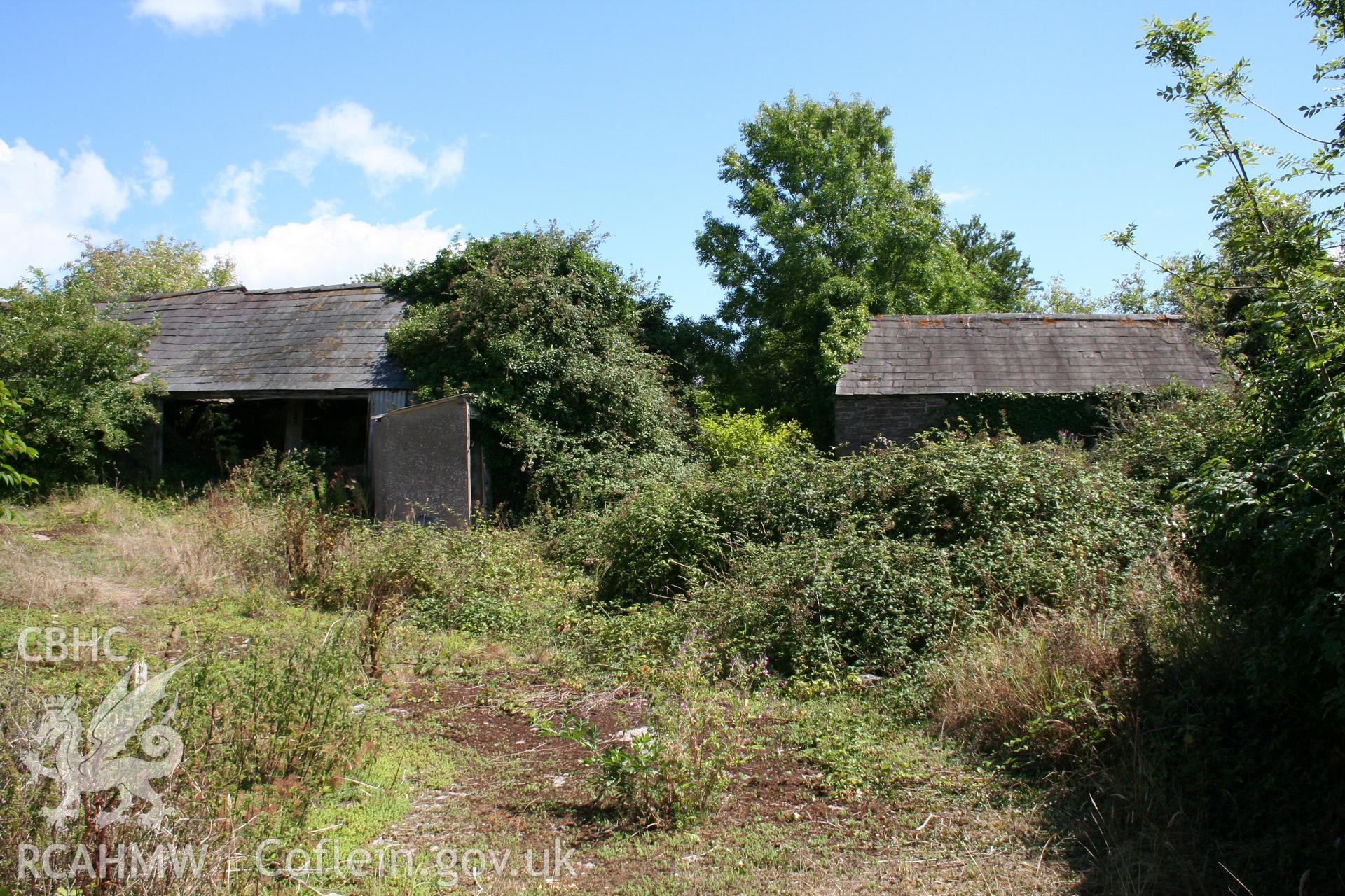 Exterior view of cow-house at right angles to barn with detached bull house to right.