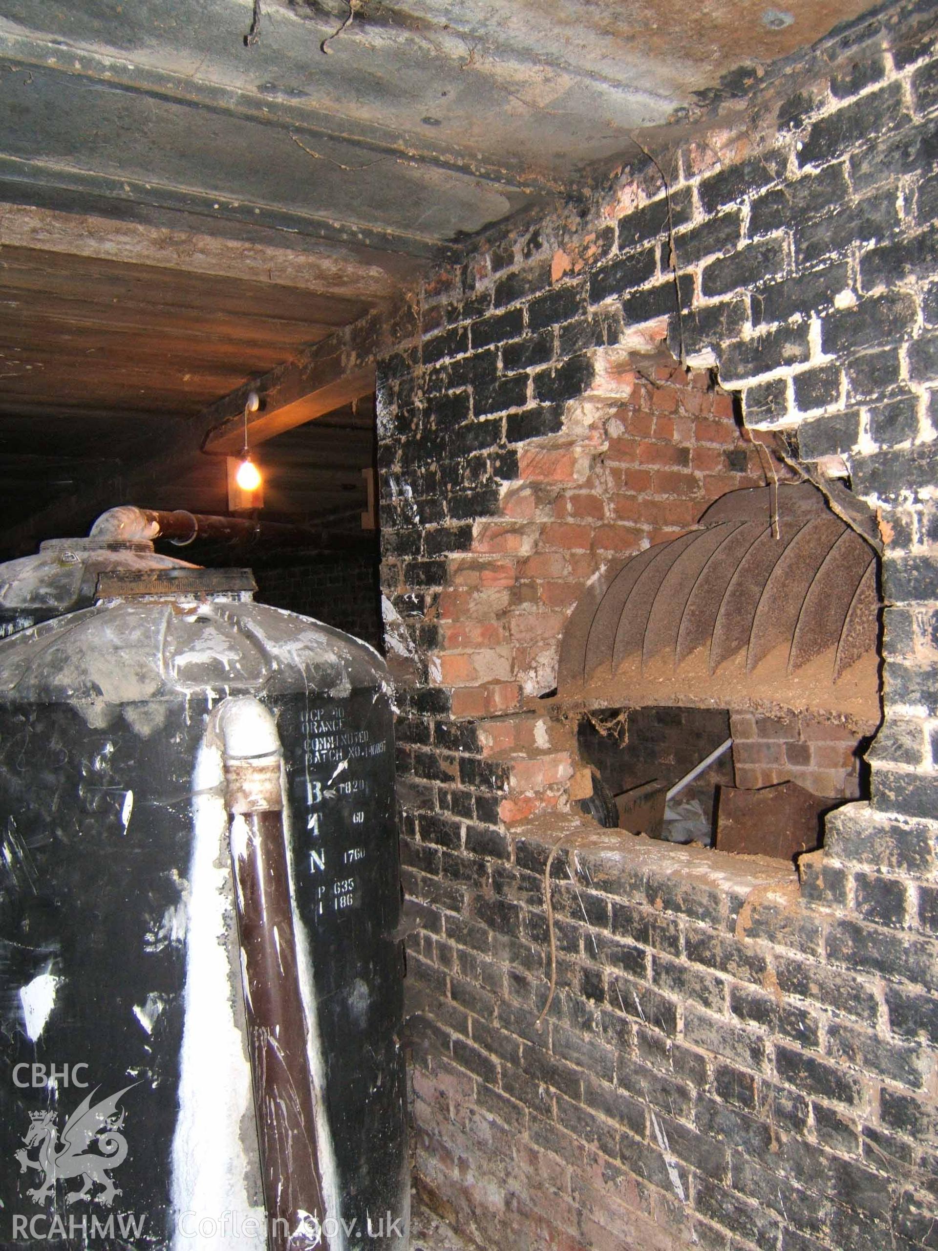 Stove and brick surround in centre-west of sheep-drying house basement