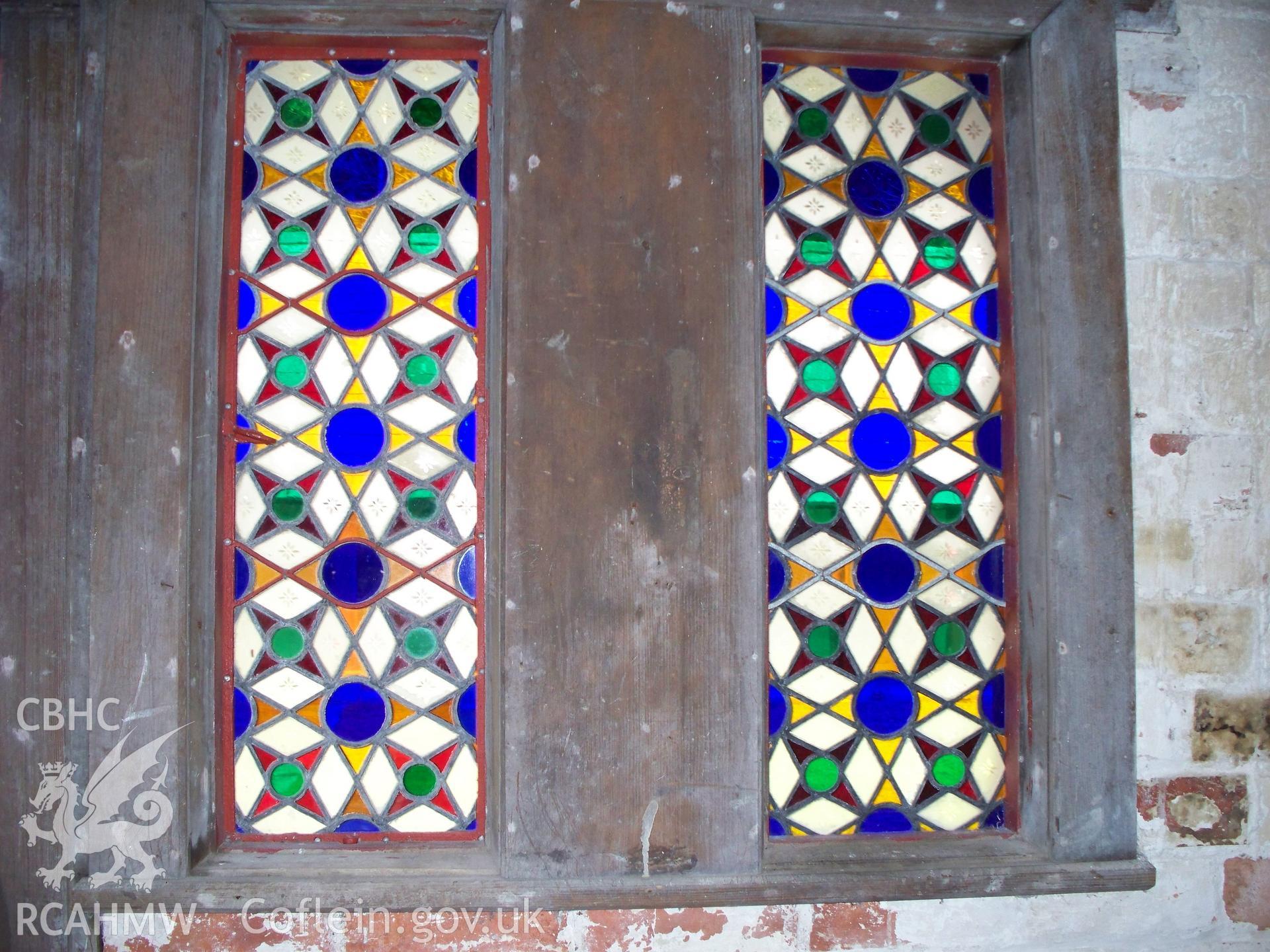 Stained-glass windows alongside the NW central door of the Poultry House.