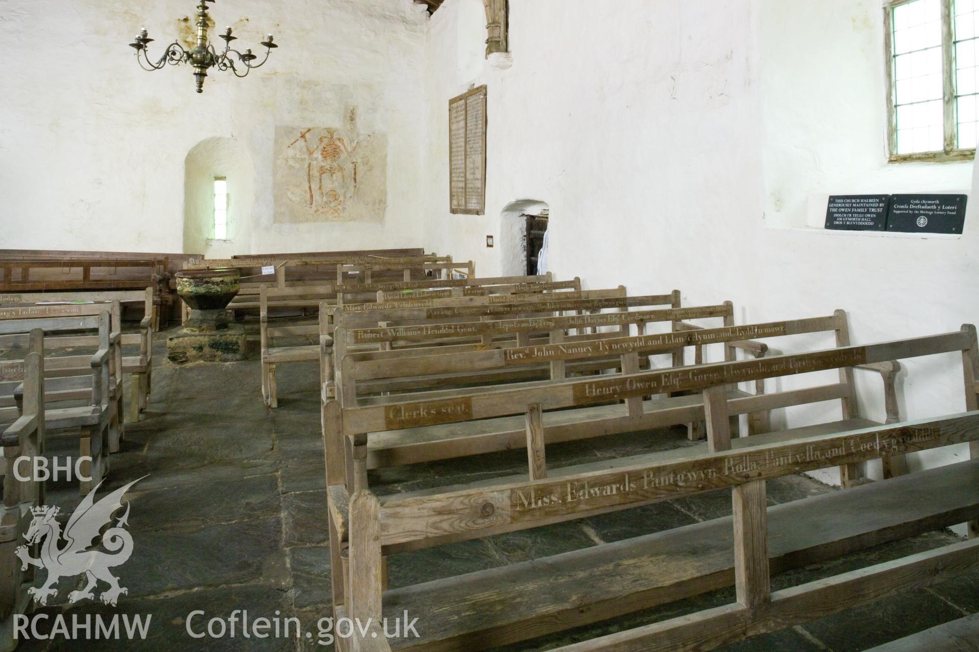 Detail of pews, with Memento Mori in background.