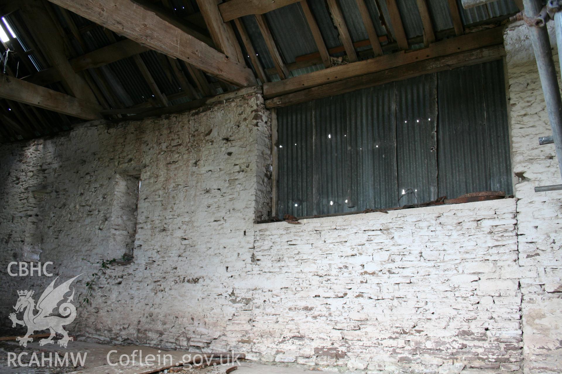 Interior of framed barn, showing later later ventilation openings in stone.