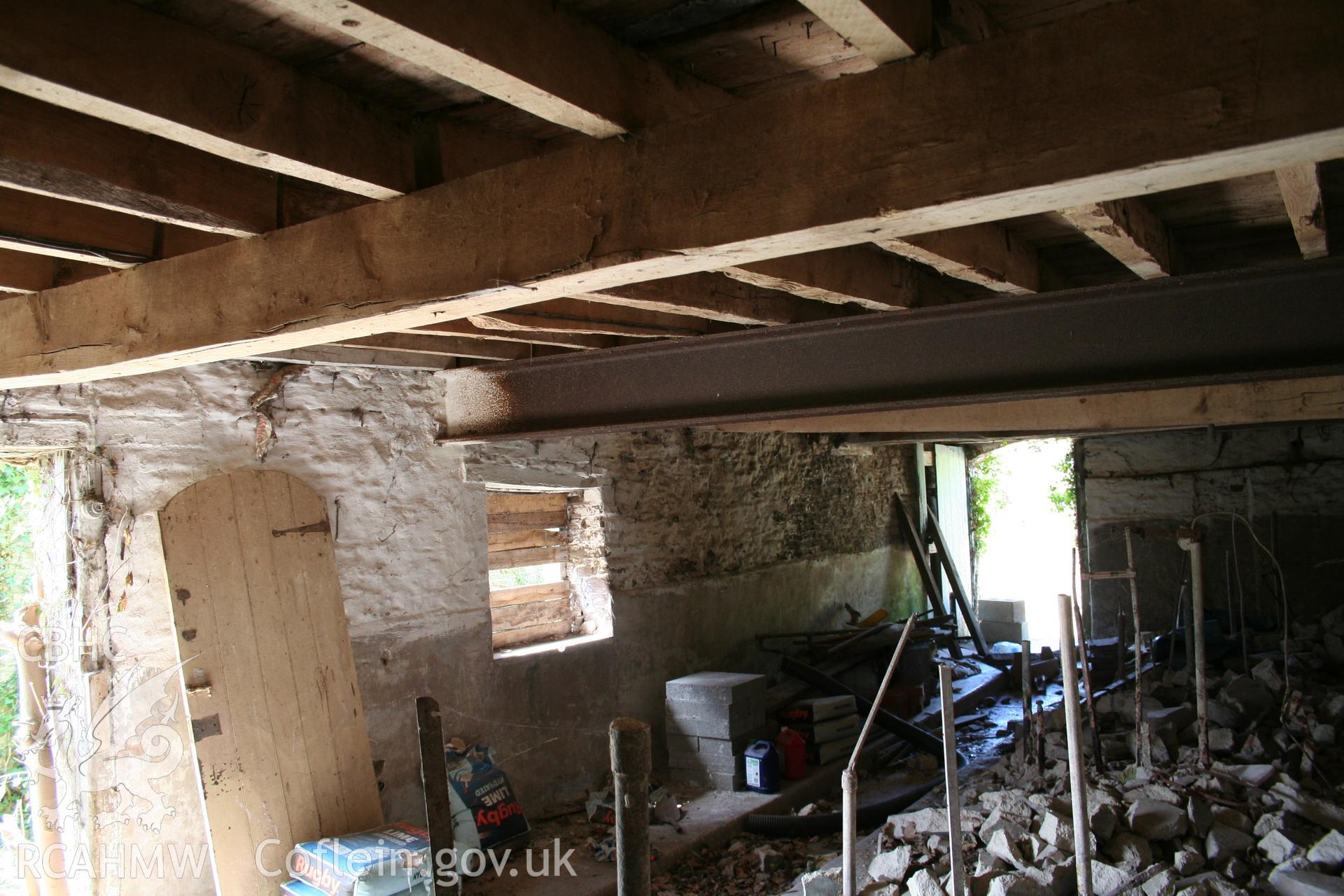 Interior of cow/house stable with later cattle doorway to east gable-end. nd stable doorway to north-east.