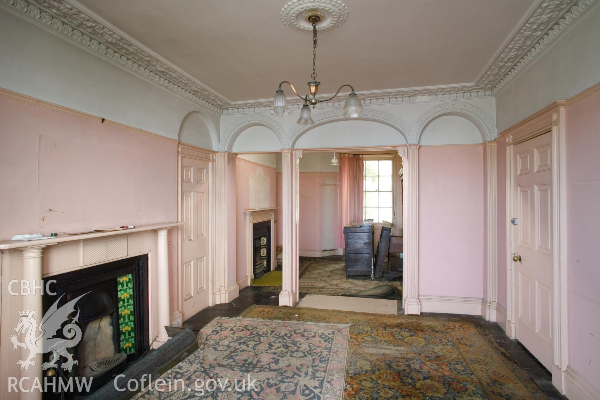 Ground floor front room, looking southeast to rear divided room.